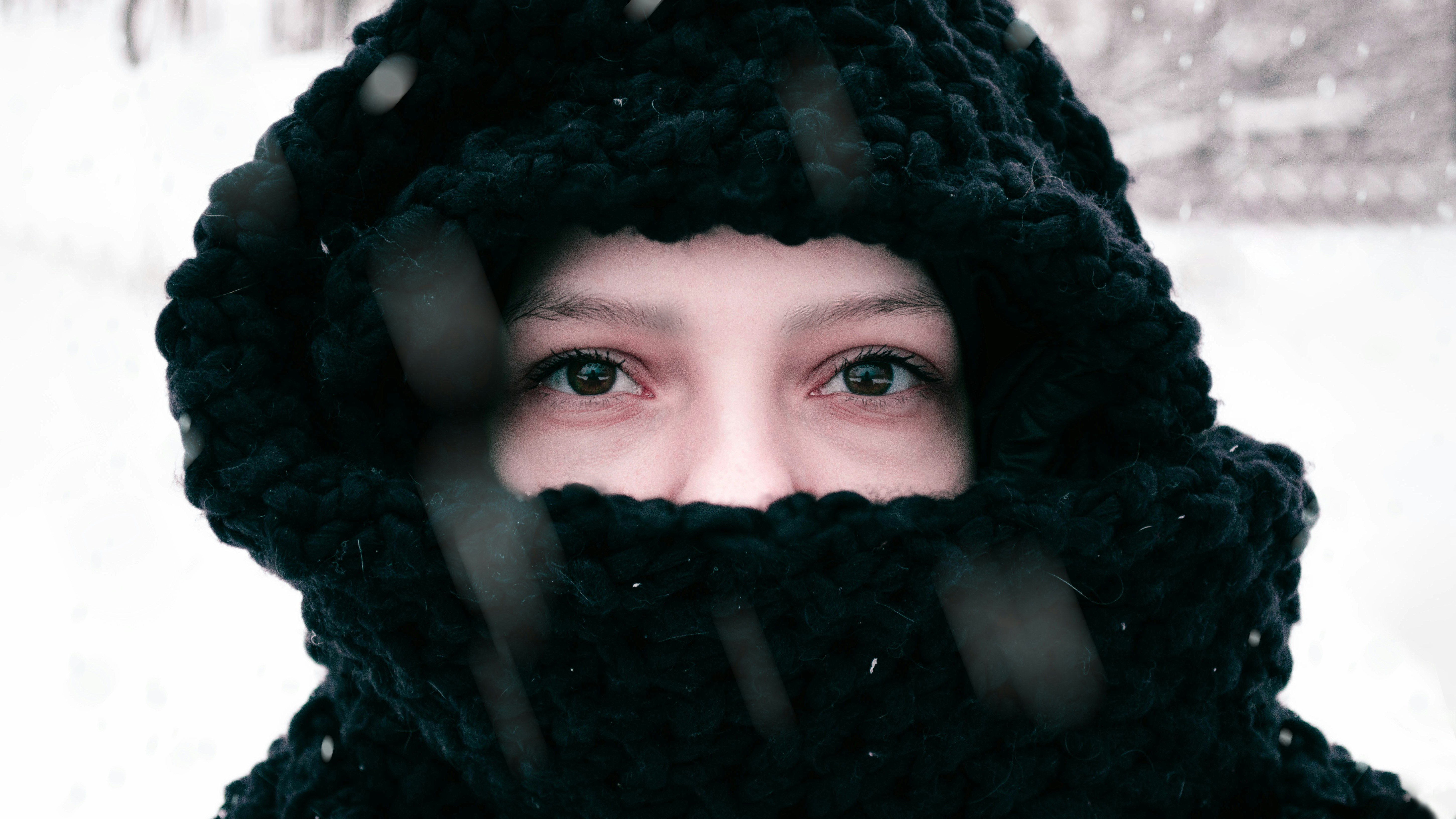 a woman wearing a black scarf and a black hat