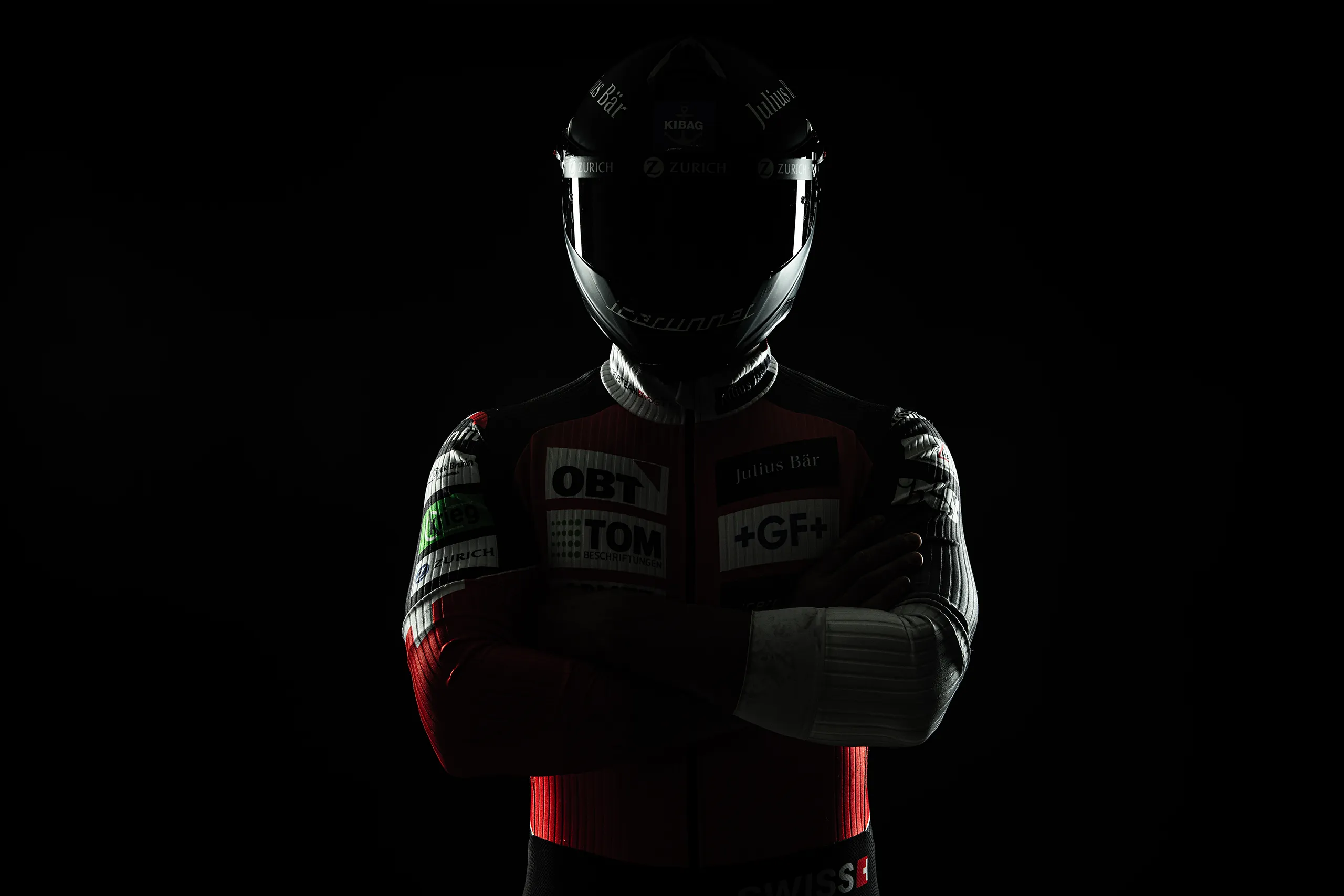 Dramatic silhouette of a bobsled athlete with sharp rim lighting and helmet.
