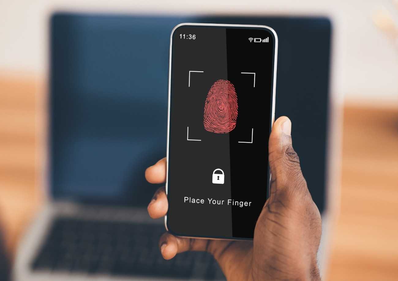 man holding phone with fingerprint scanning