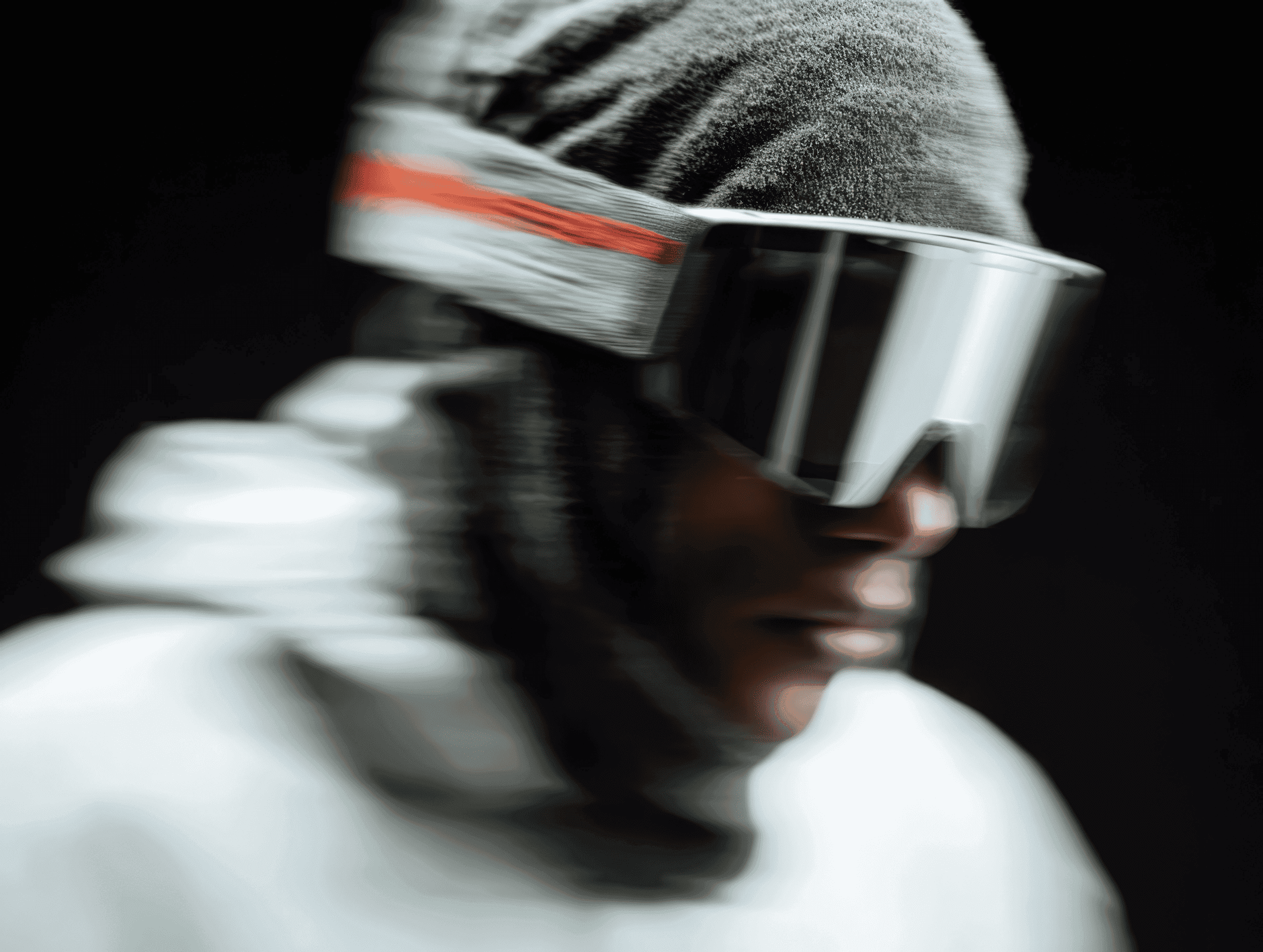 Side profile of a person in large visor goggles wearing a beanie and hoodie