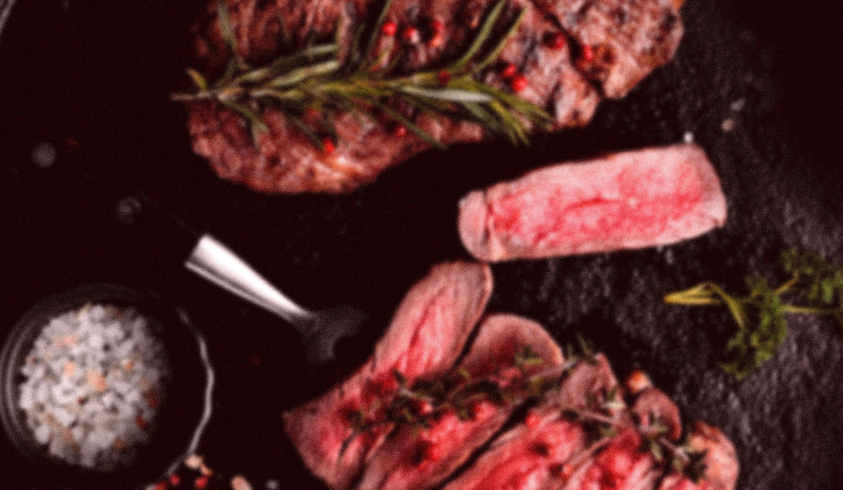 Modern indoor space with large glass doors, lush greenery, and a cozy seating area visible beyond.