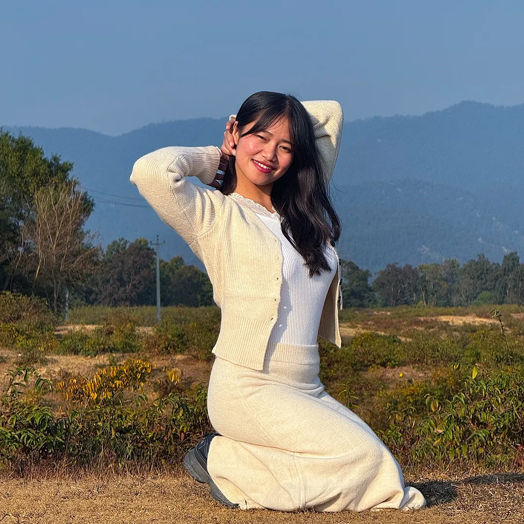 woman looking sideways leaning on white wall