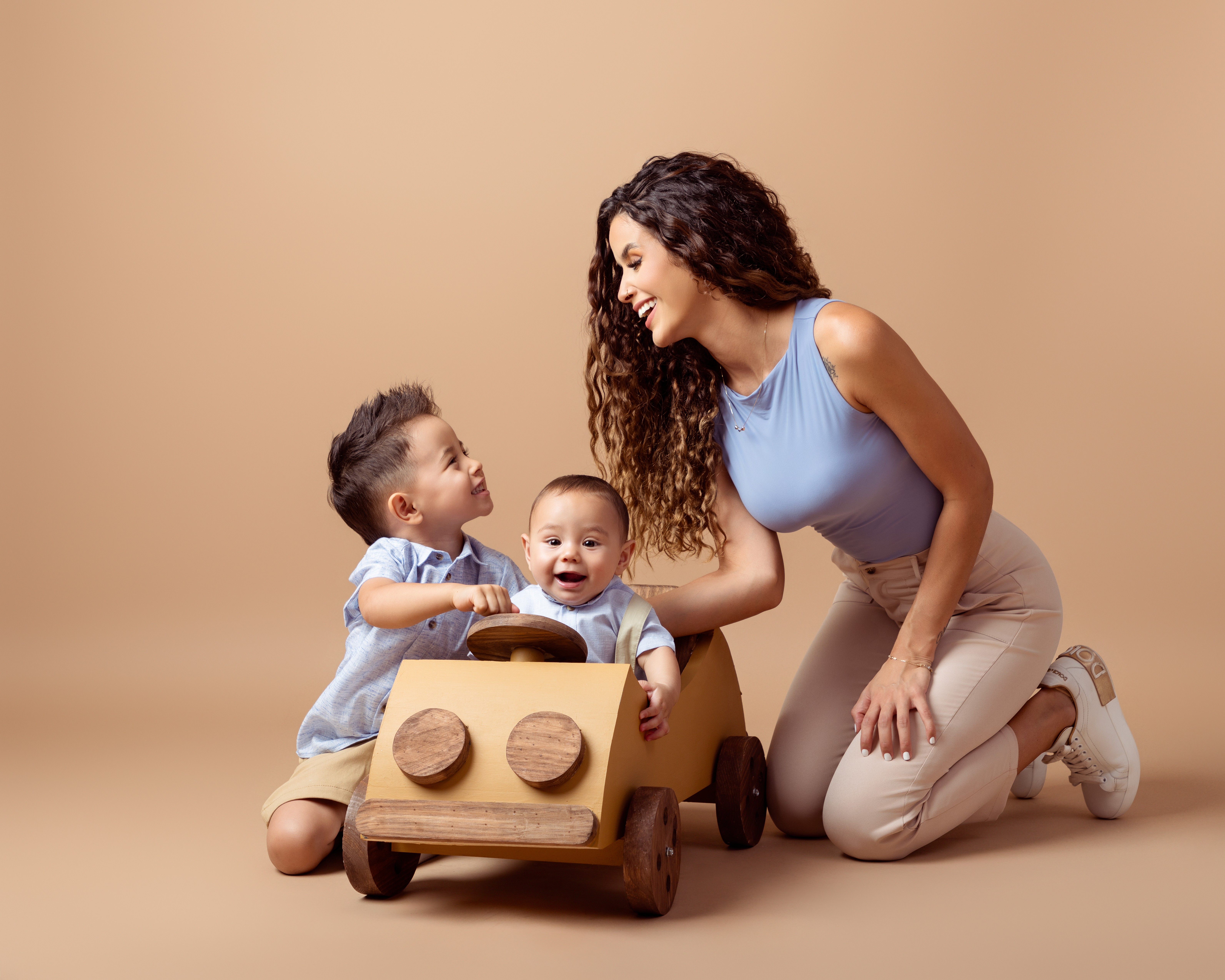 mamá divirtiendose con sus hijos en una sesión de fotos en estudio profesional