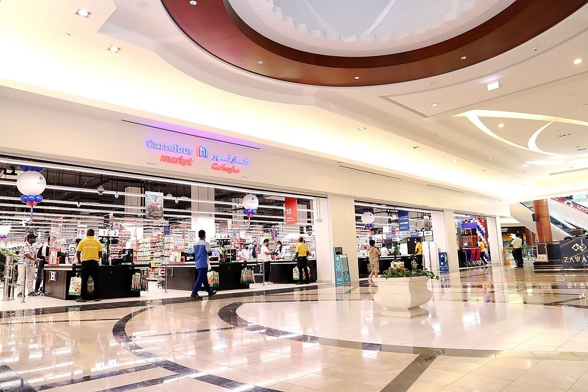 L'enseigne Carrefour Market en néon au-dessus des caisses, dans une galerie marchande de Doha, l'une des adresses Carrefour au Qatar