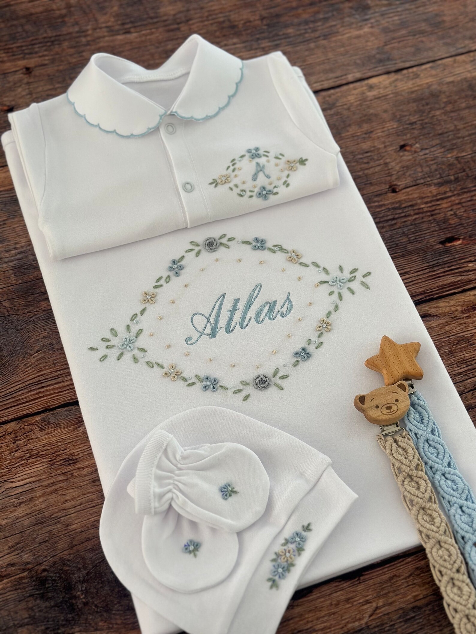 Smiling young man with short hair poses against a dark background, wearing a green button-up shirt.