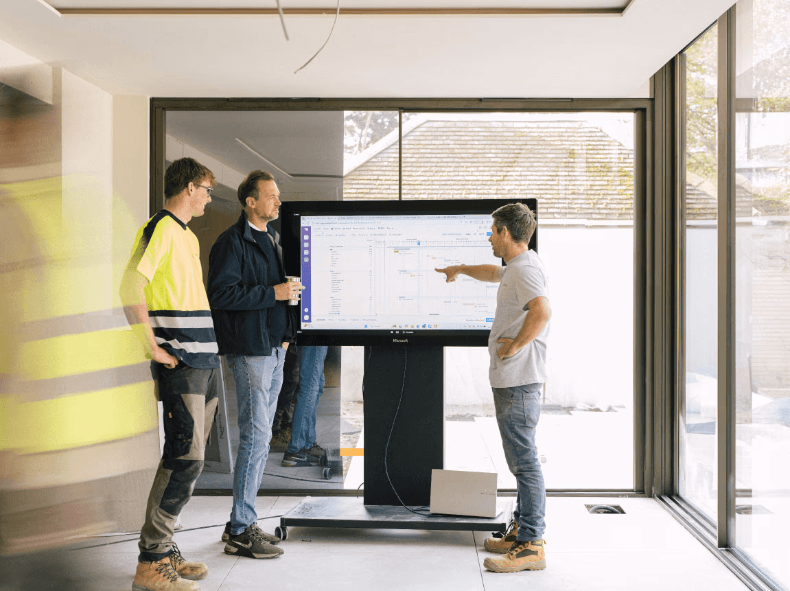 a worker shows the stages of construction on the screen