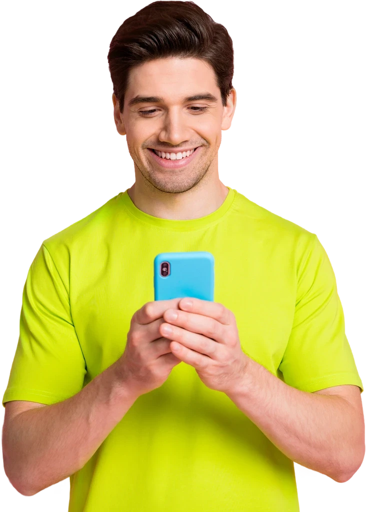 A smiling man in a green shirt holds a smartphone, looking cheerful and engaged.