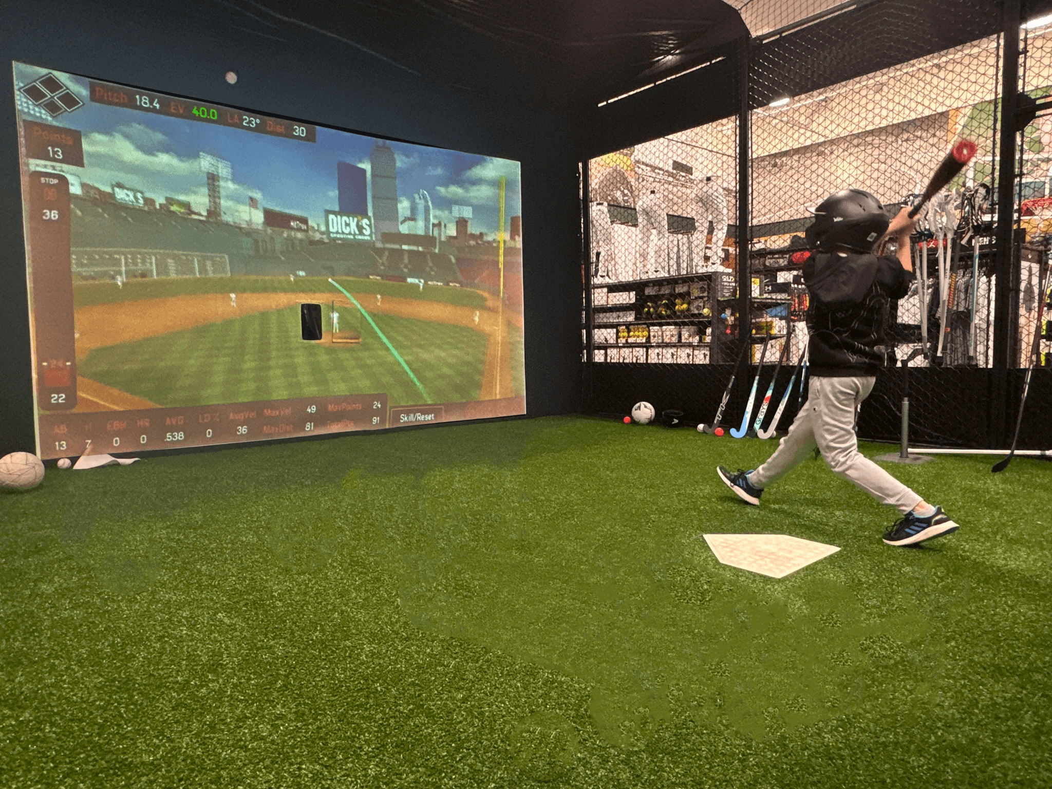 HitTrax Suite batting cage with netted hitting area and turf flooring inside Dick’s Sporting Goods.