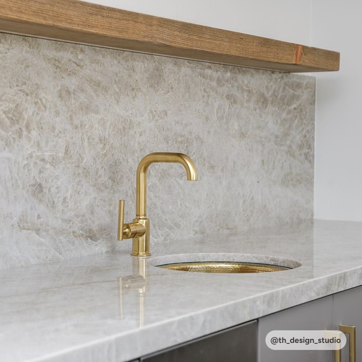 taj mahal quartzite countertop with grey cabinets and gold hardware