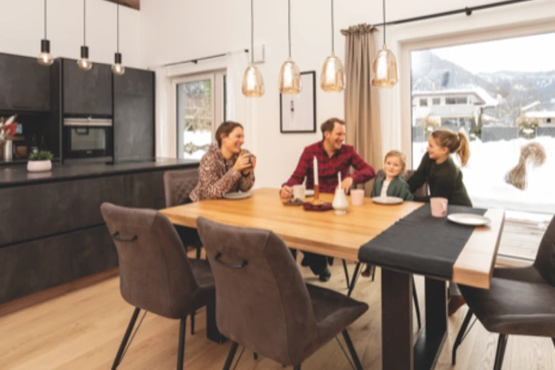 Family dining at a table in a cozy, modern kitchen.