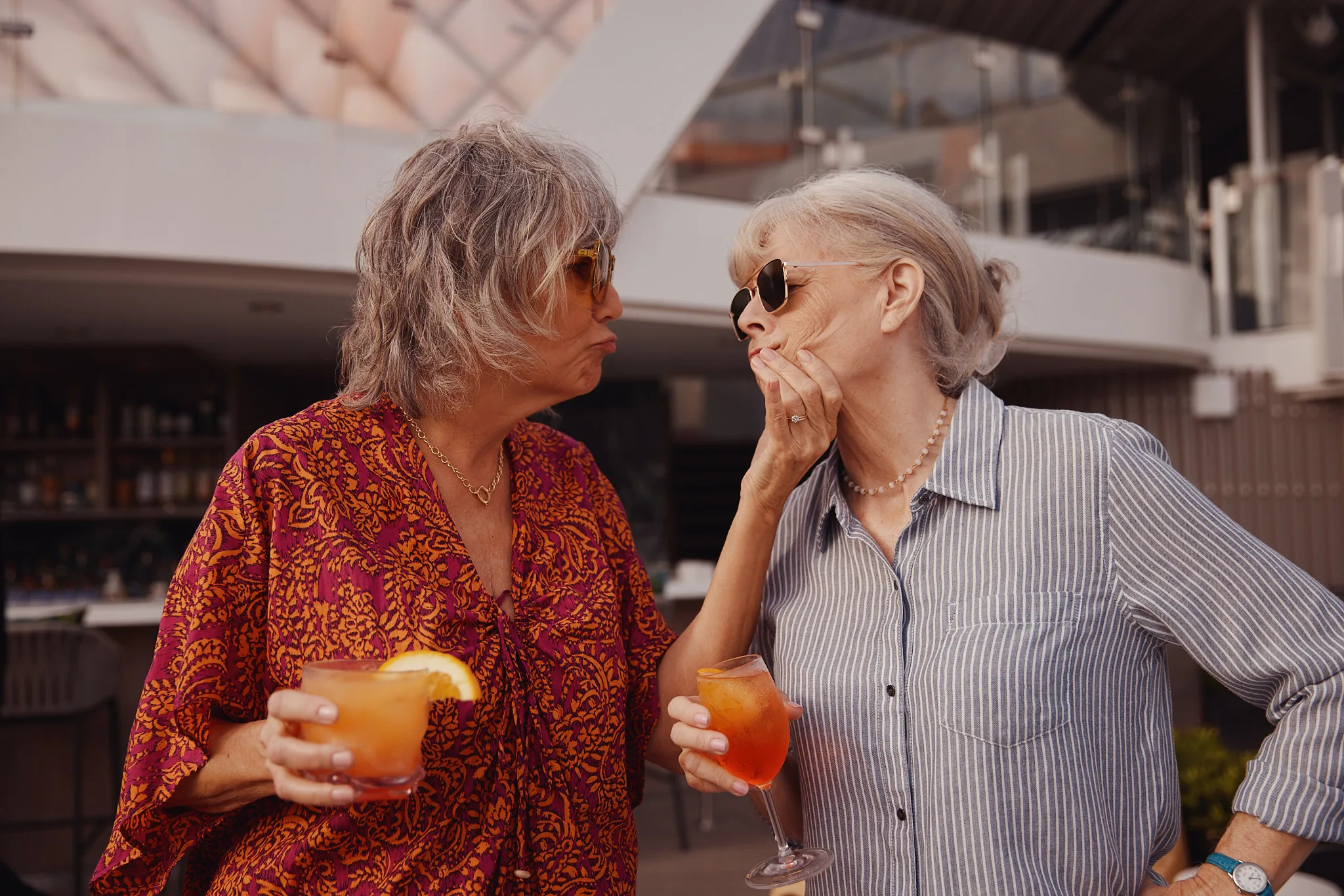 two women sharing cocktails on rooftop — lifestyle photography by Tom Kubik
