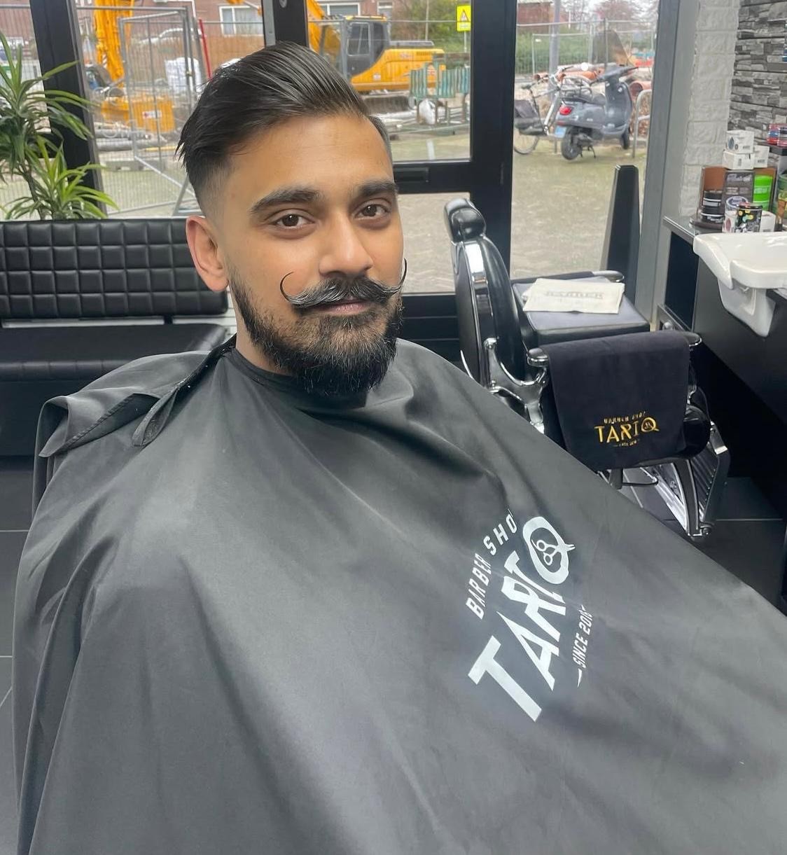 Barber posing with razor and scissor