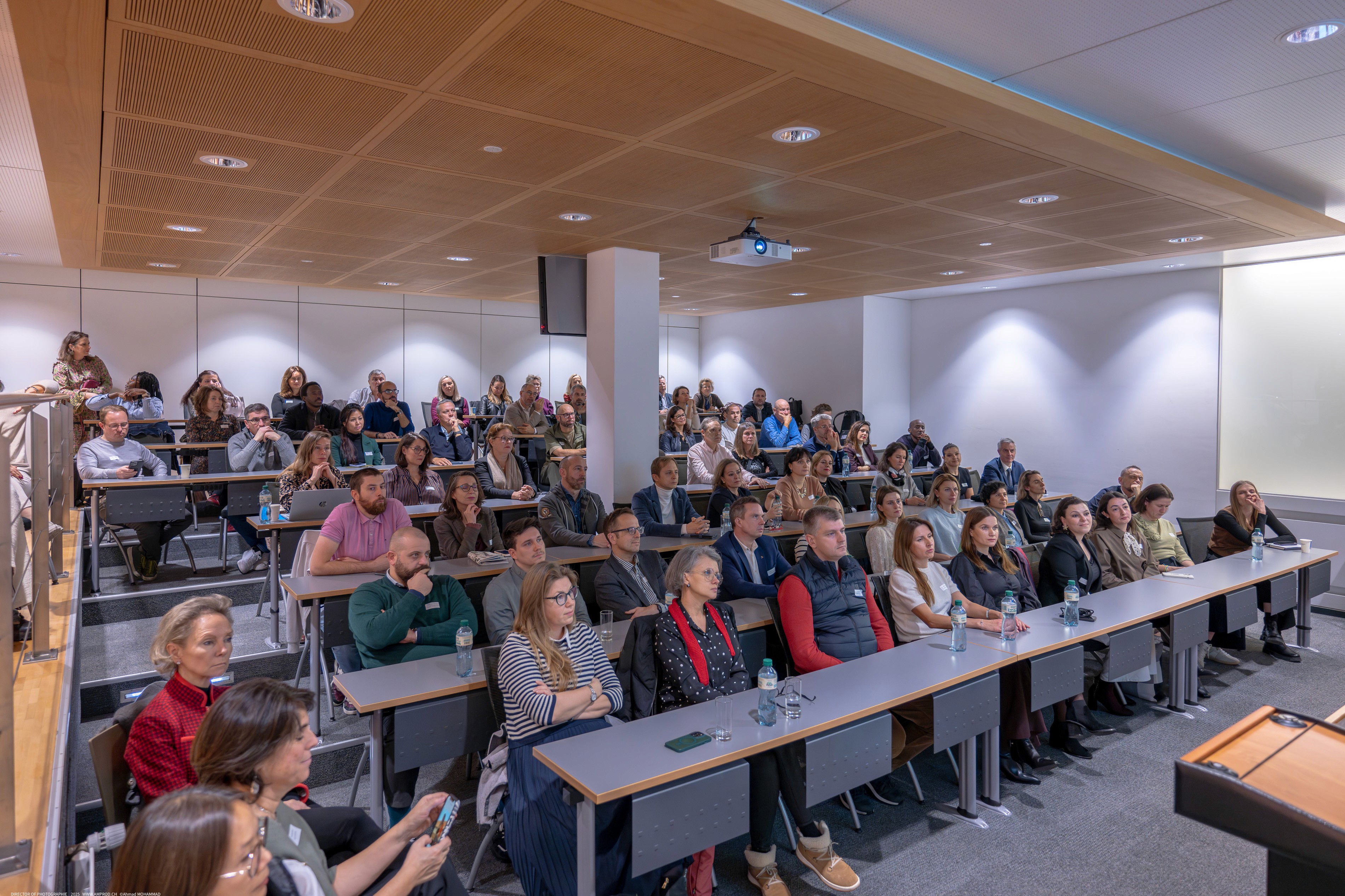 Large audience attending a conference presentation in a modern lecture hall