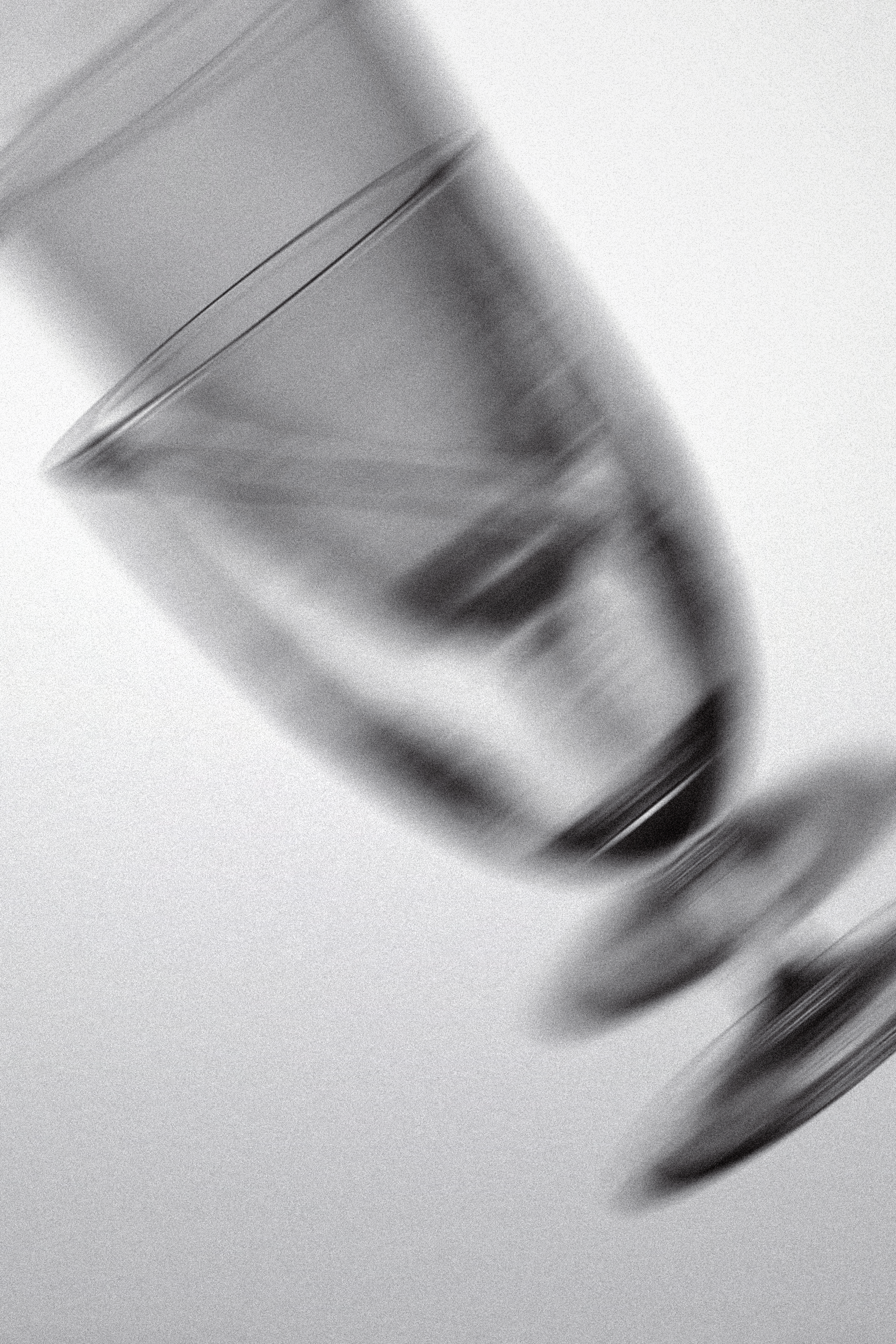 Tilted wine glass in monochrome on a clean white background.