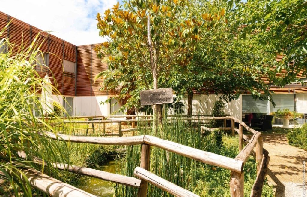 Full view of residence complex with contemporary design	balconies	and surrounding pine fores