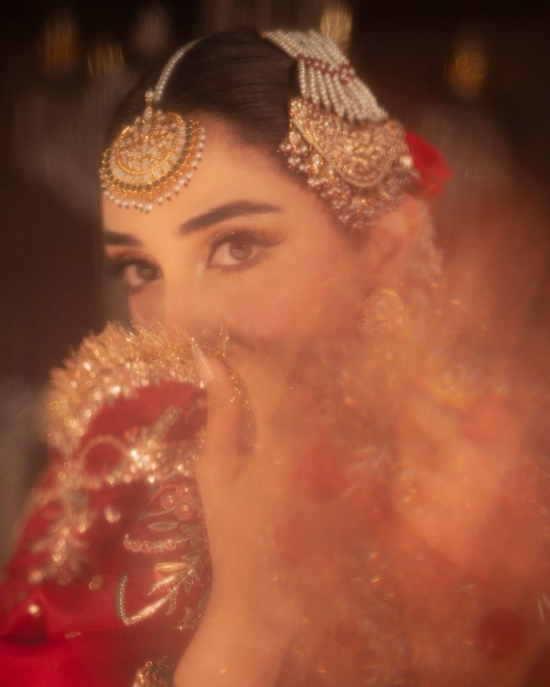 A woman in a bridal outfit sitting on a couch