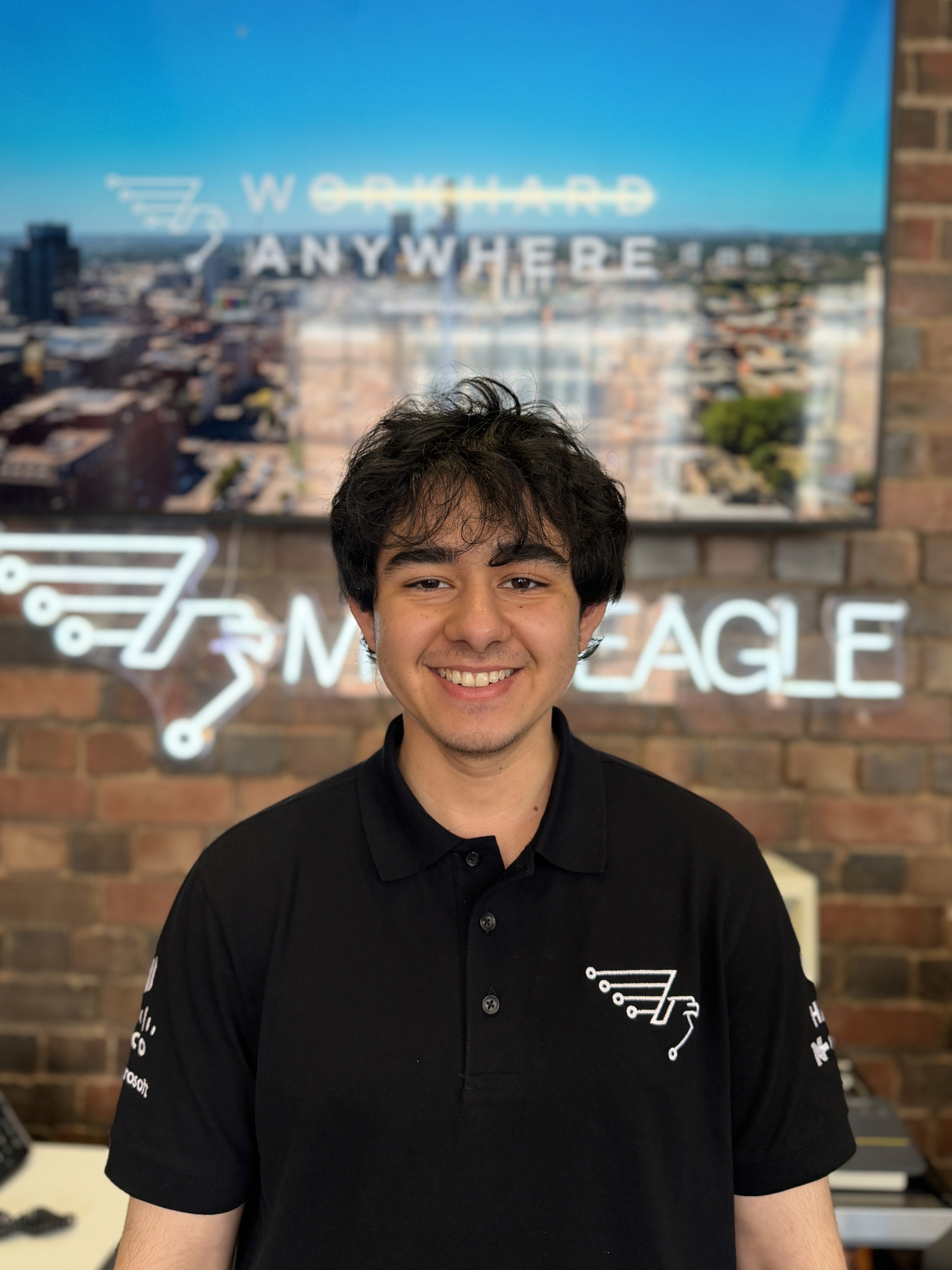A man with glasses and a brown shirt, crossing his arms.