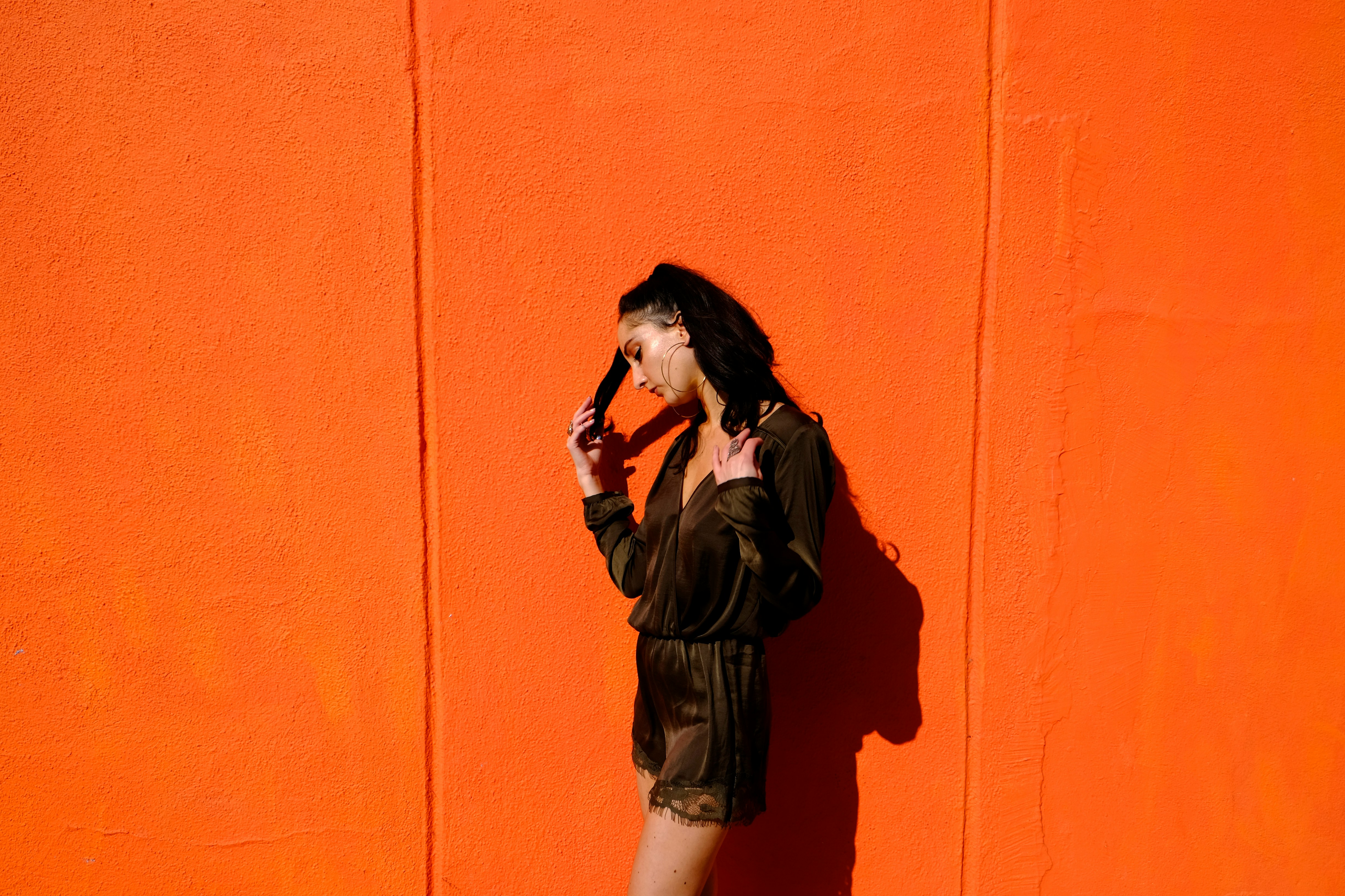 Girl Standing infront of Orange Background - Preppy Girl