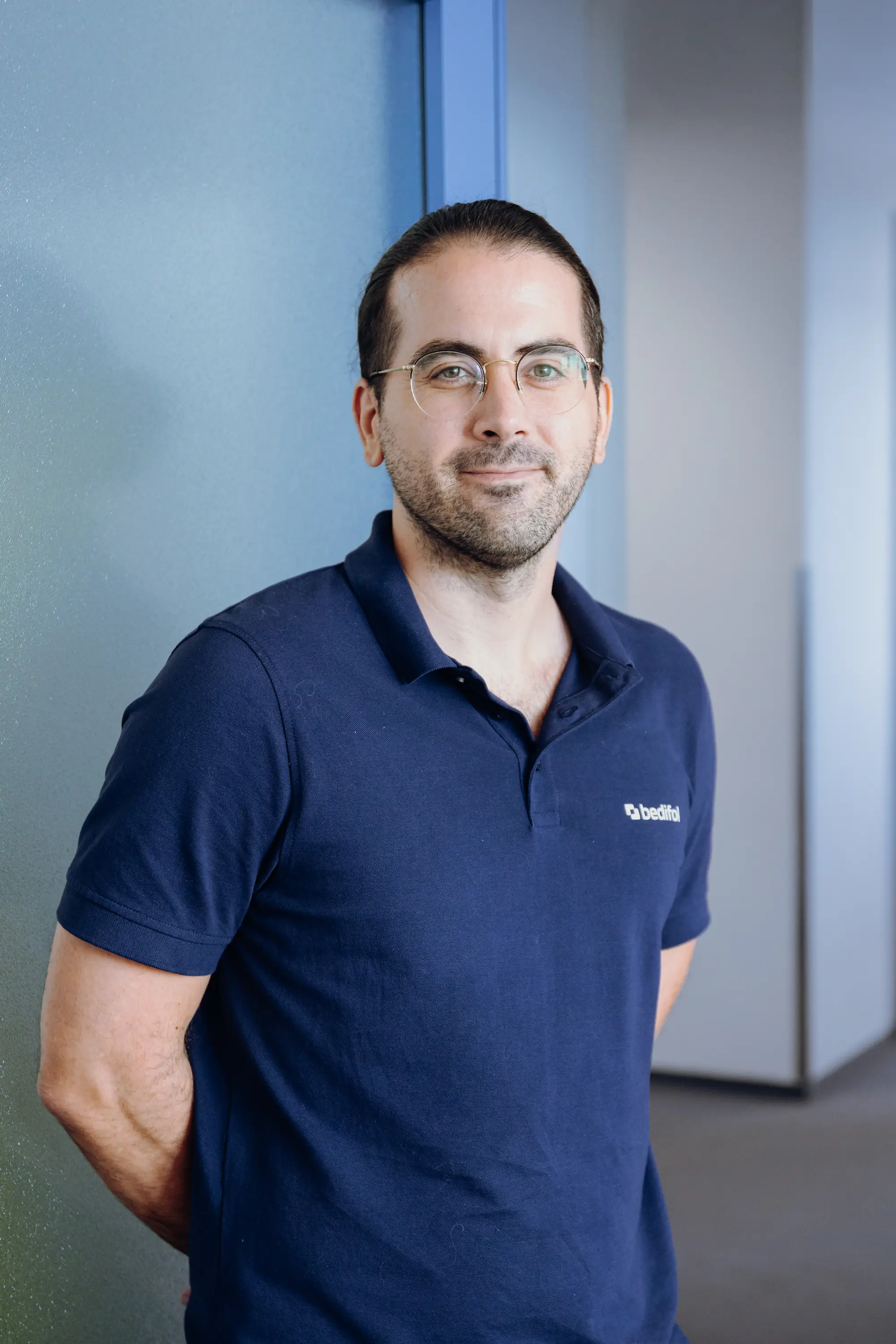 A man in a dark blue Bedifol polo shirt.