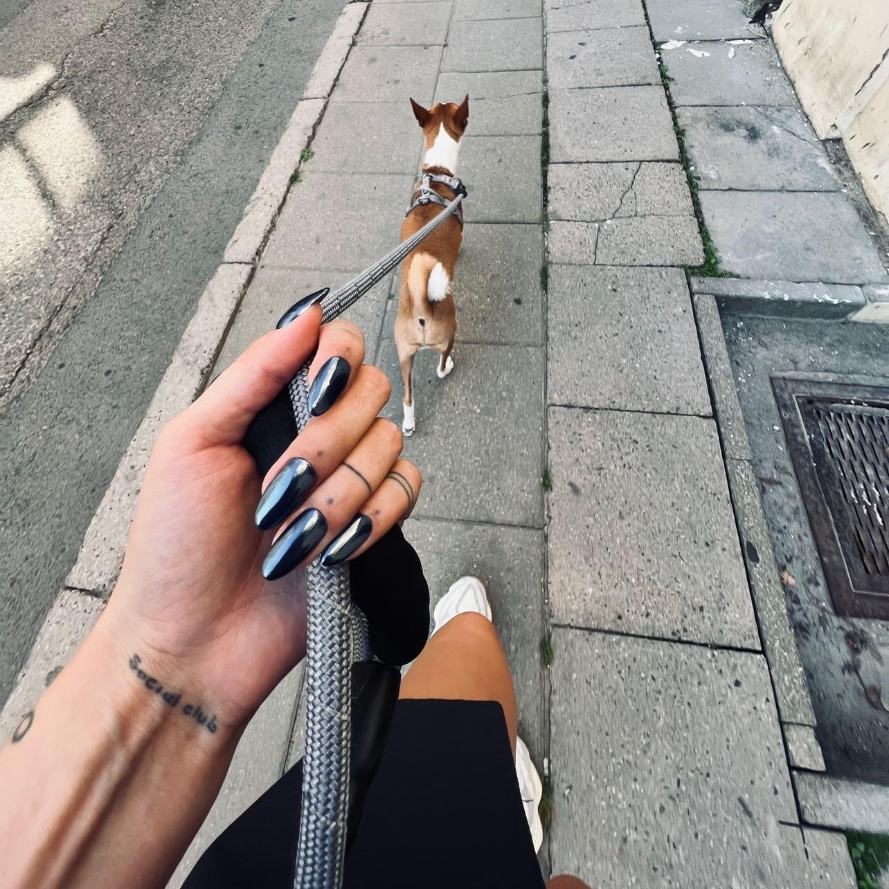 Hand with pink swirl nails and rings in car
