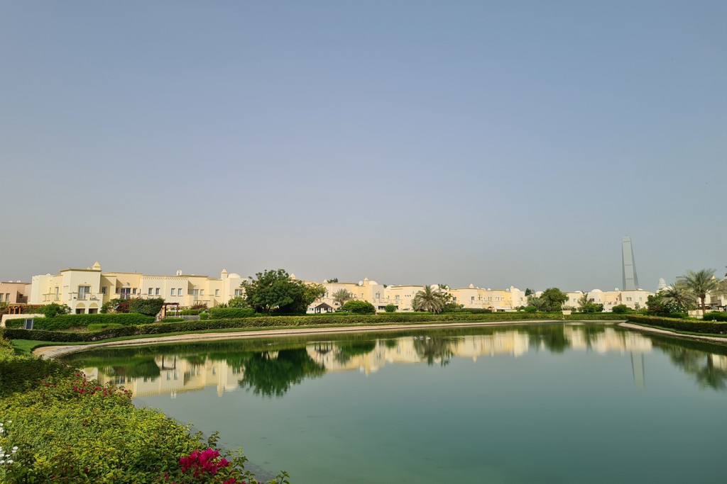 Serene pond, Springs 2 community building: greenery, structure reflection.