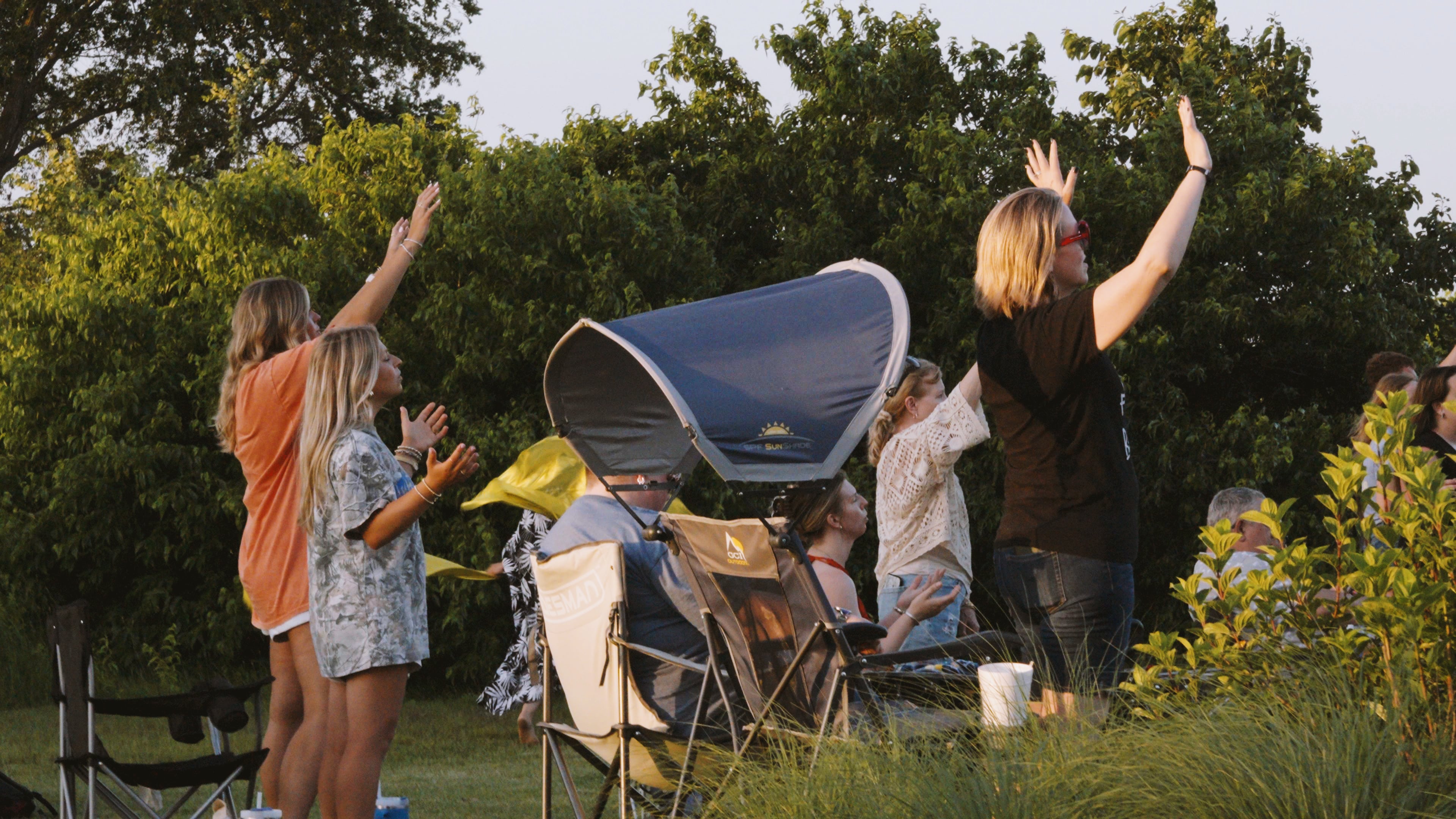 People lifting their hands in worship during Worship Night.
