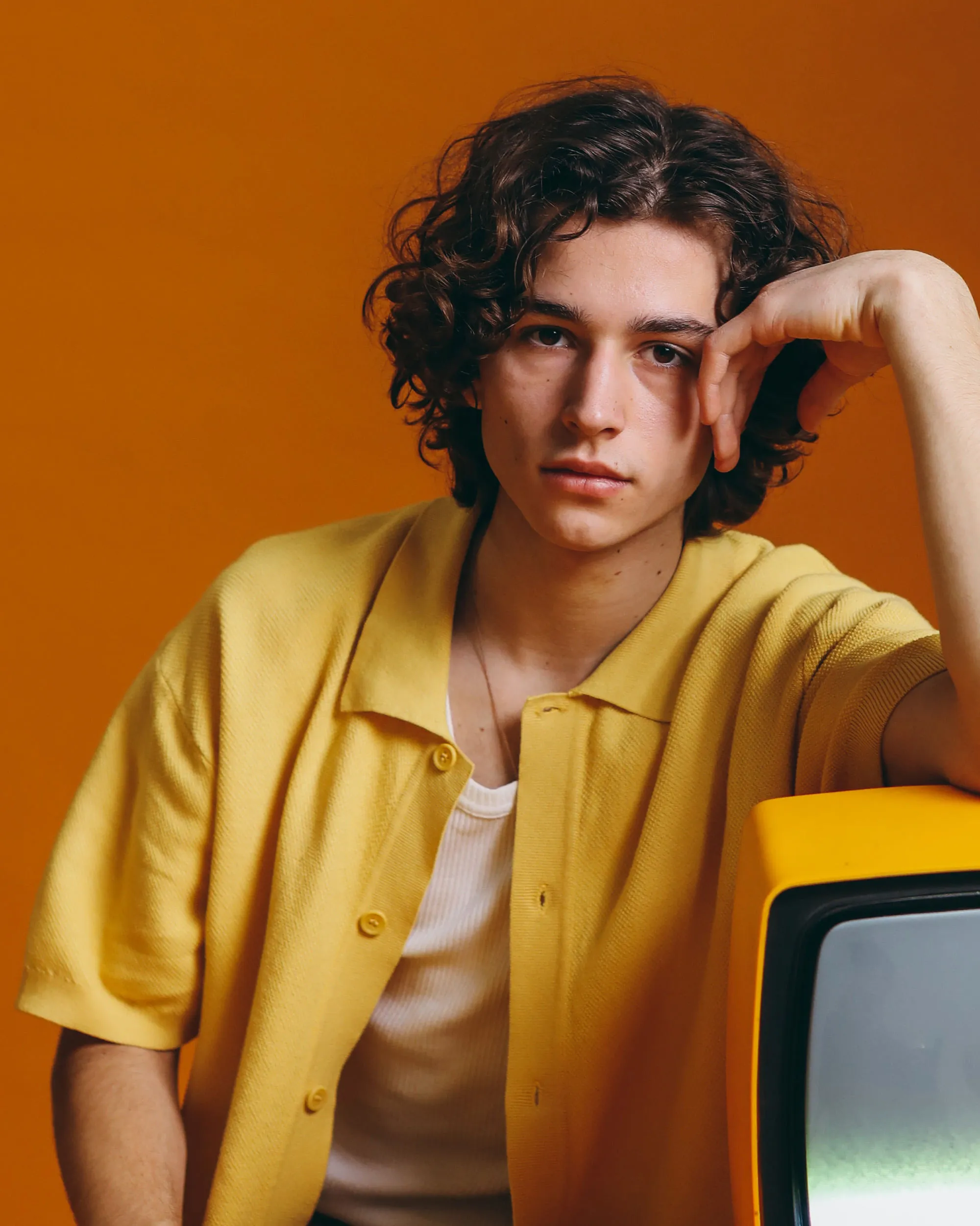 Grand stone building with glowing windows under a deep blue twilight. Dramatic lighting casts a mysterious, elegant ambiance. Surrounded by shadowy trees.