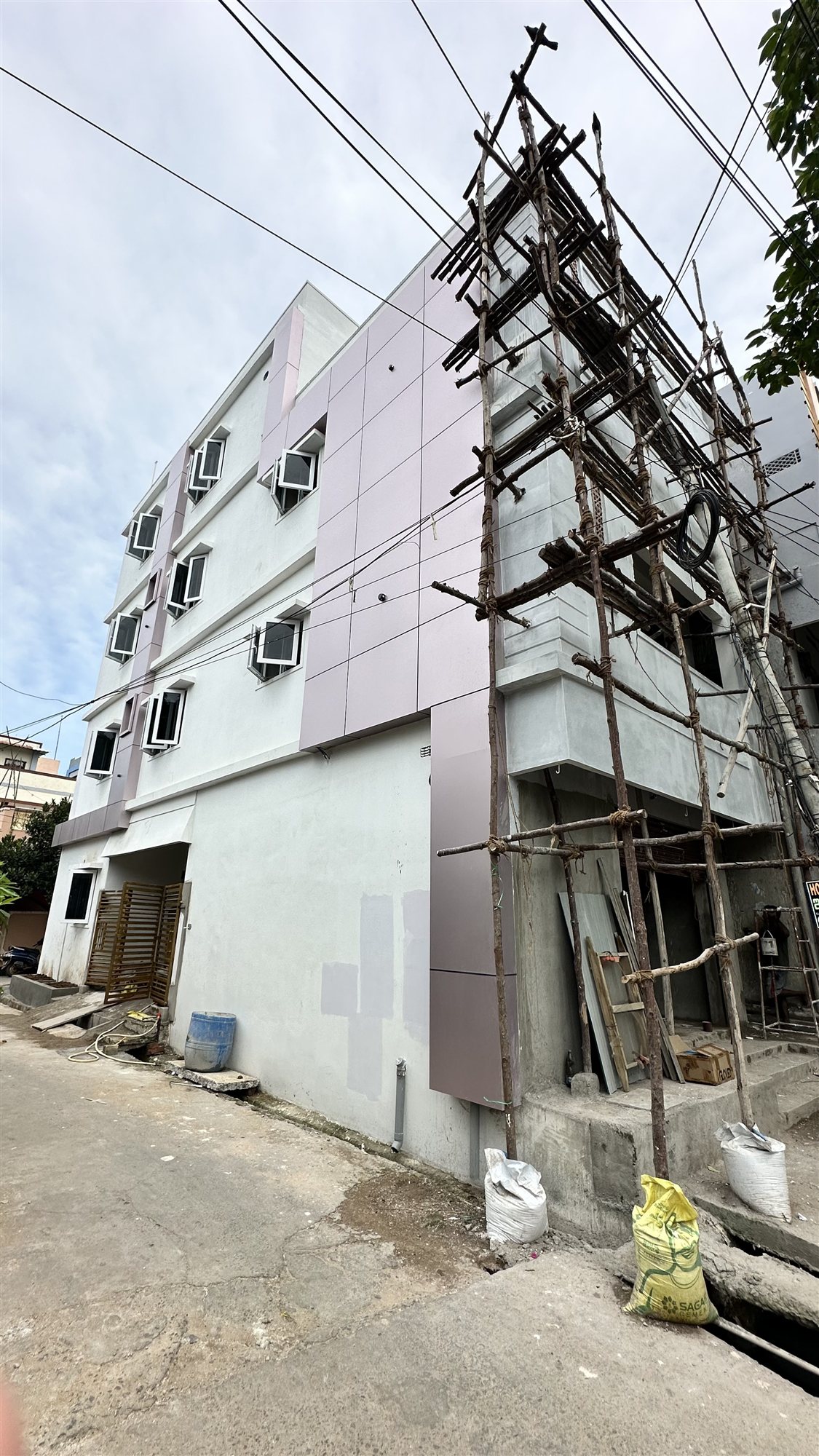 Mr. Raveendra Kumar's three-storey home in Rajahmundry with grey and white facade panels