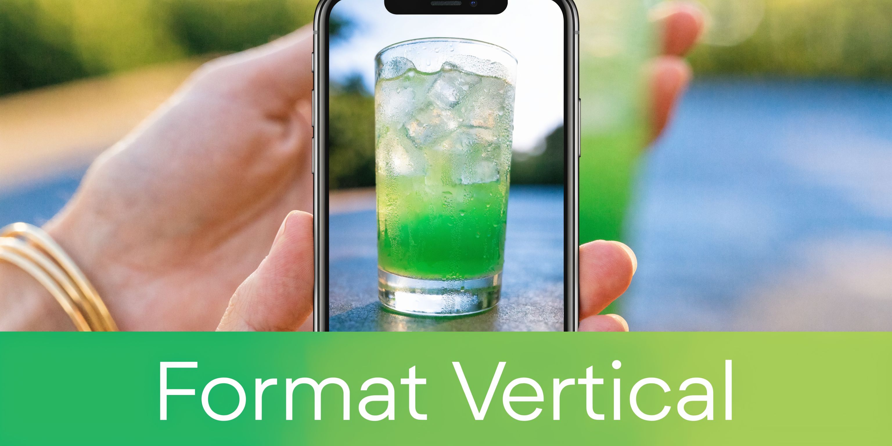 Une main tient un smartphone affichant une photo verticale d'un verre de boisson verte rafraîchissante.