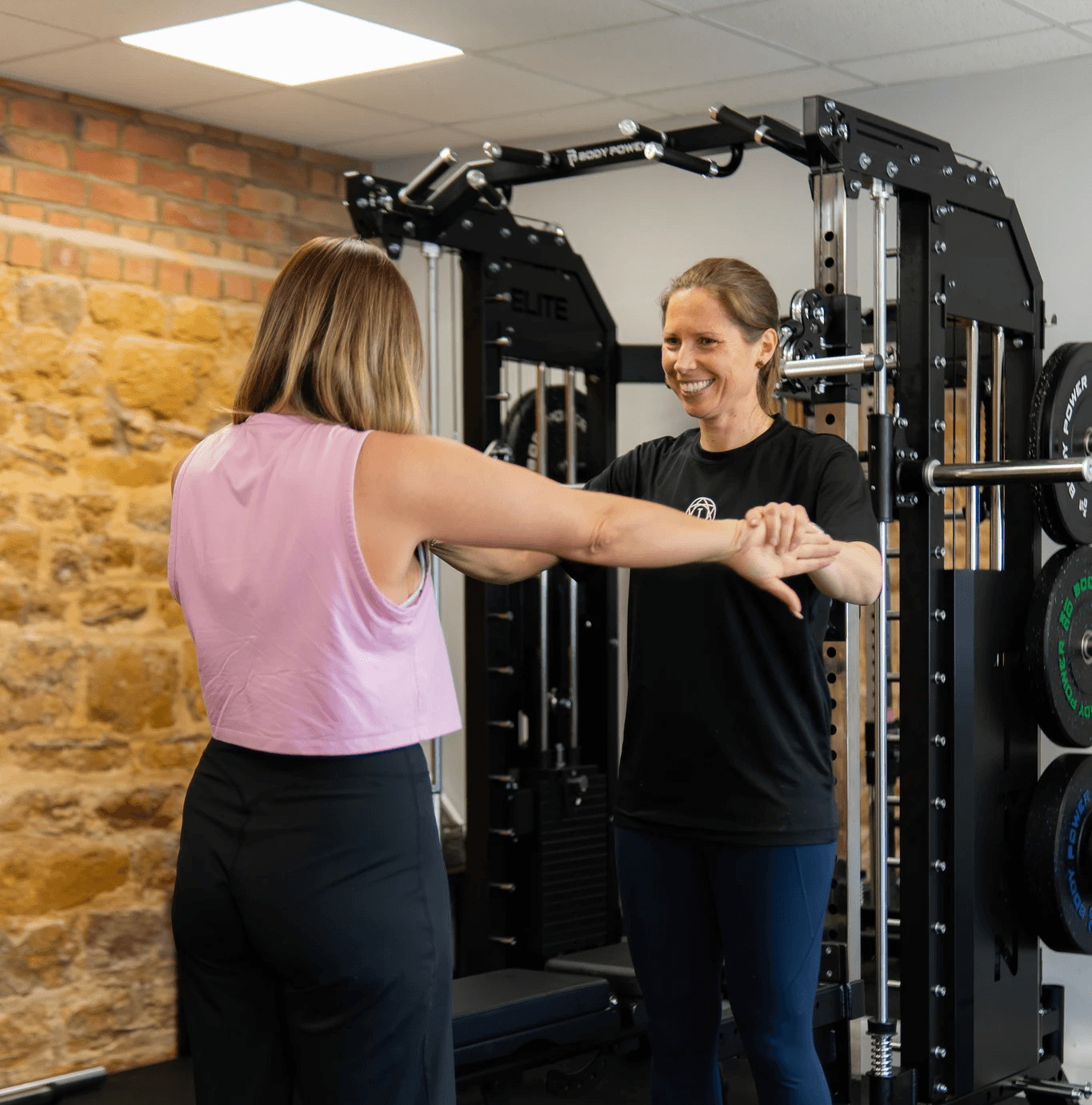Woman putting weight onto smith machine in private gym