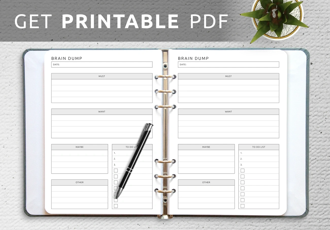 Open binder showing printable brain dump template with sections for must, want, maybe, other, and to-do list with pen and plant nearby.
