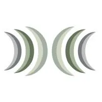 A young woman with long brown hair smiles warmly against a green background, dressed in a black jacket and white shirt.