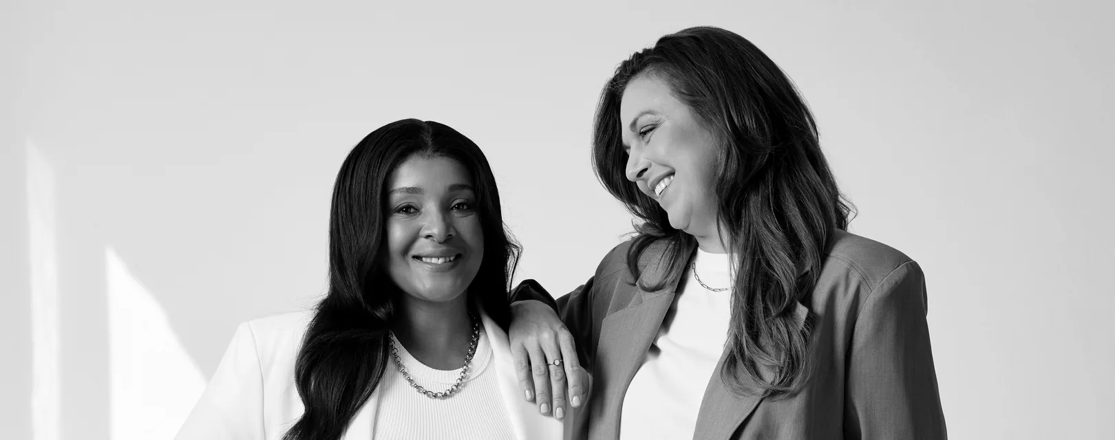 Sēkret founders Roz and Zola standing together in a bright studio, in black and white