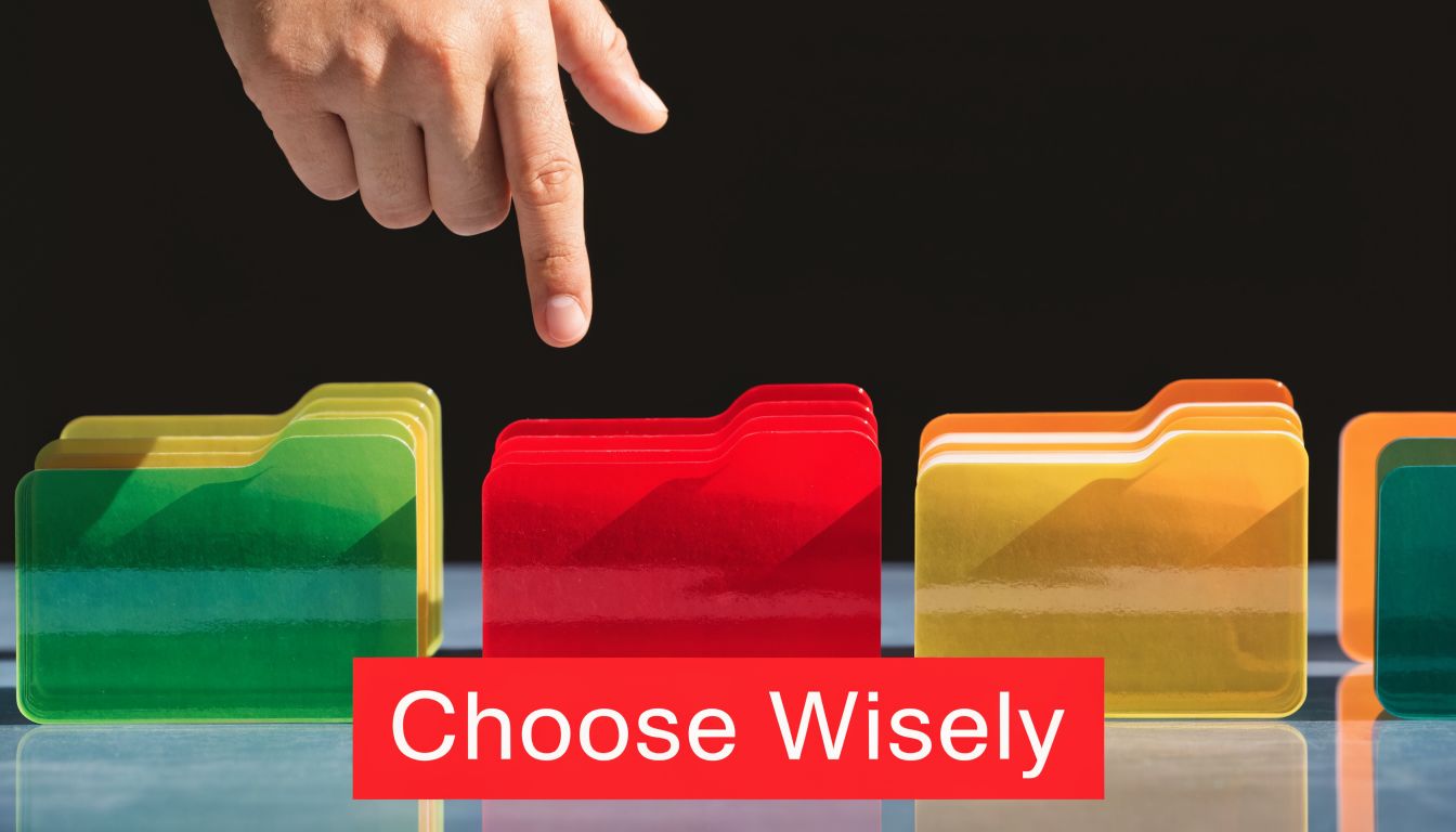 A human finger points to a red folder among several colorful office document folders on a desk.