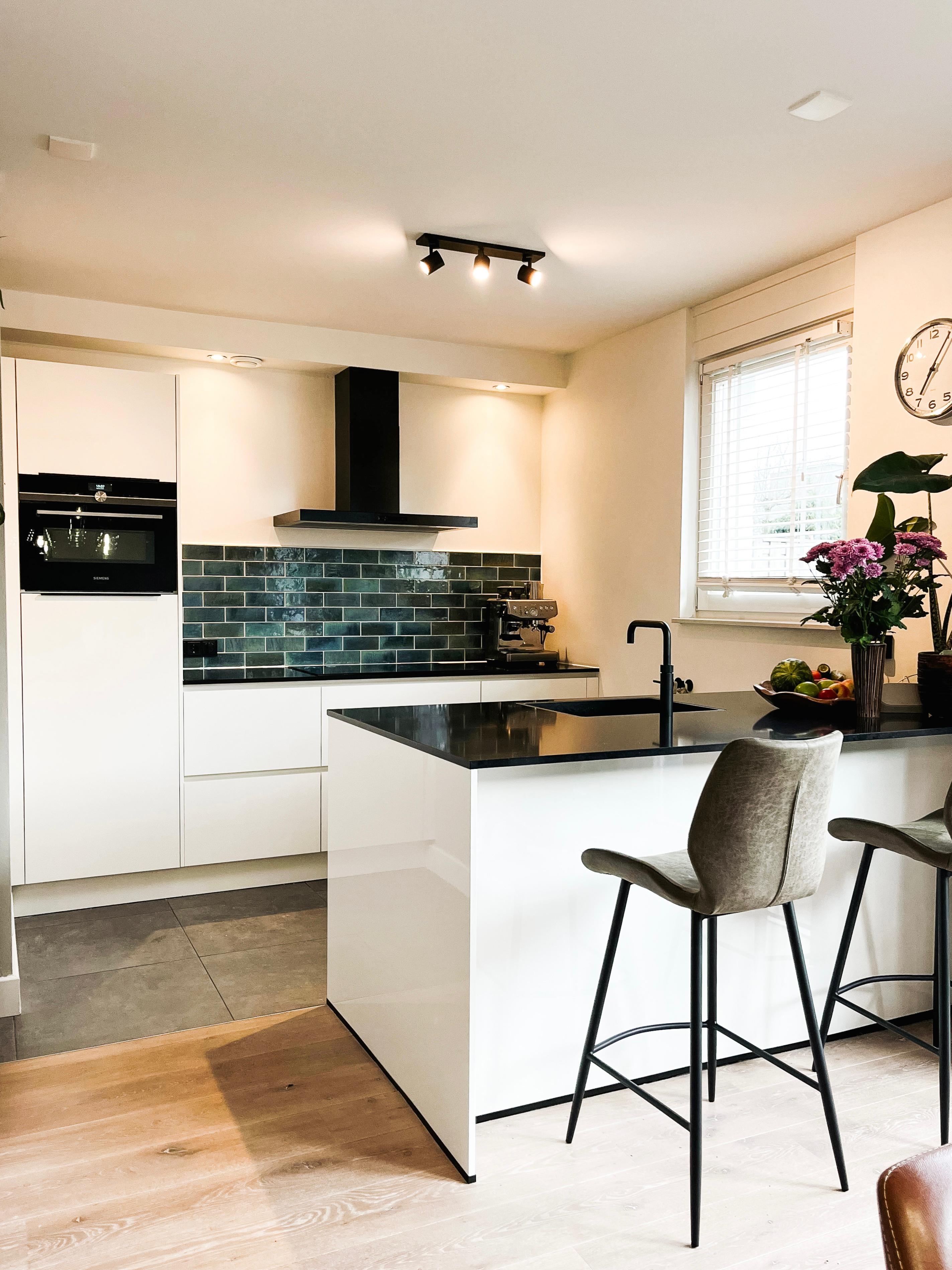 "Moderne keuken met open indeling, witte kastjes, marmeren werkblad en stainless steel apparaten, perfect voor koken en dineren. Het lichte interieur biedt veel opbergruimte en een gezellige sfeer met een ruim kookeiland.