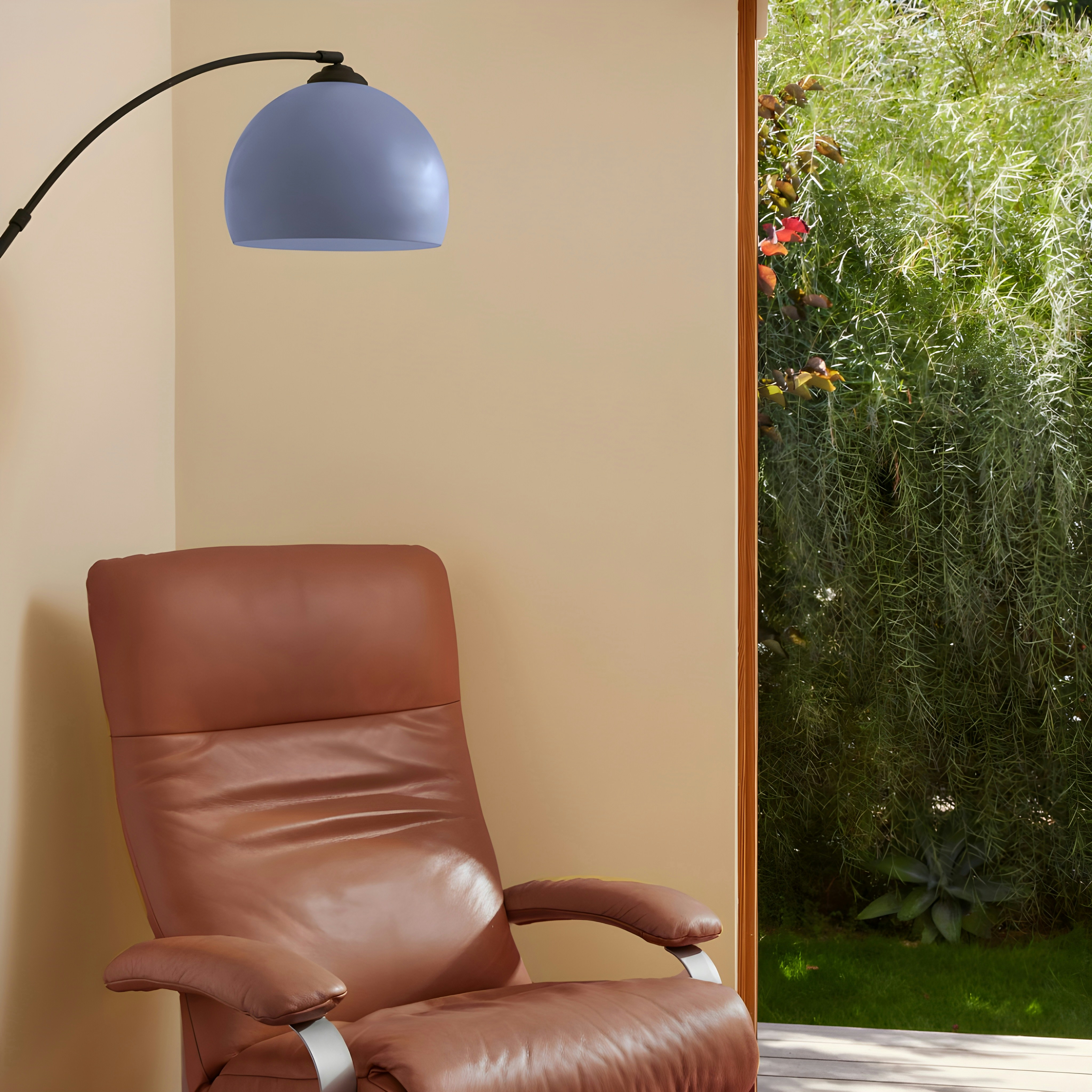 Leather armchair and arc lamp near doorway to garden