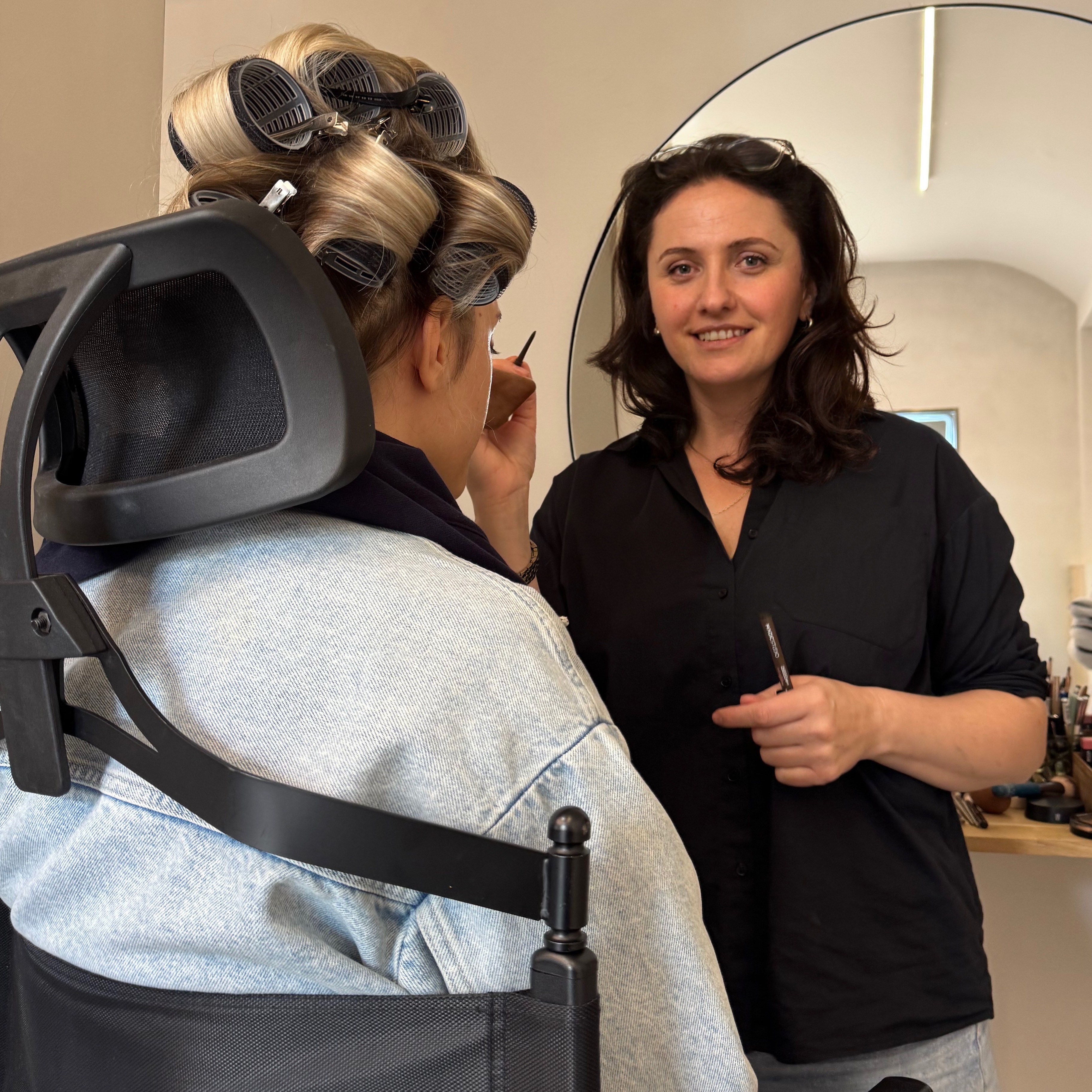 a woman getting her hair cut by a hair stylist