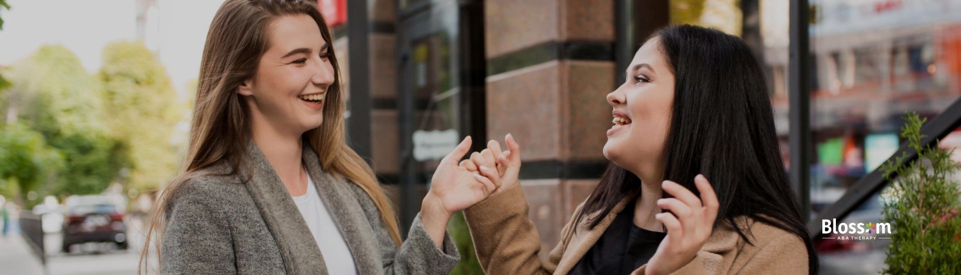 Two women laughing and enjoying a conversation outdoors.