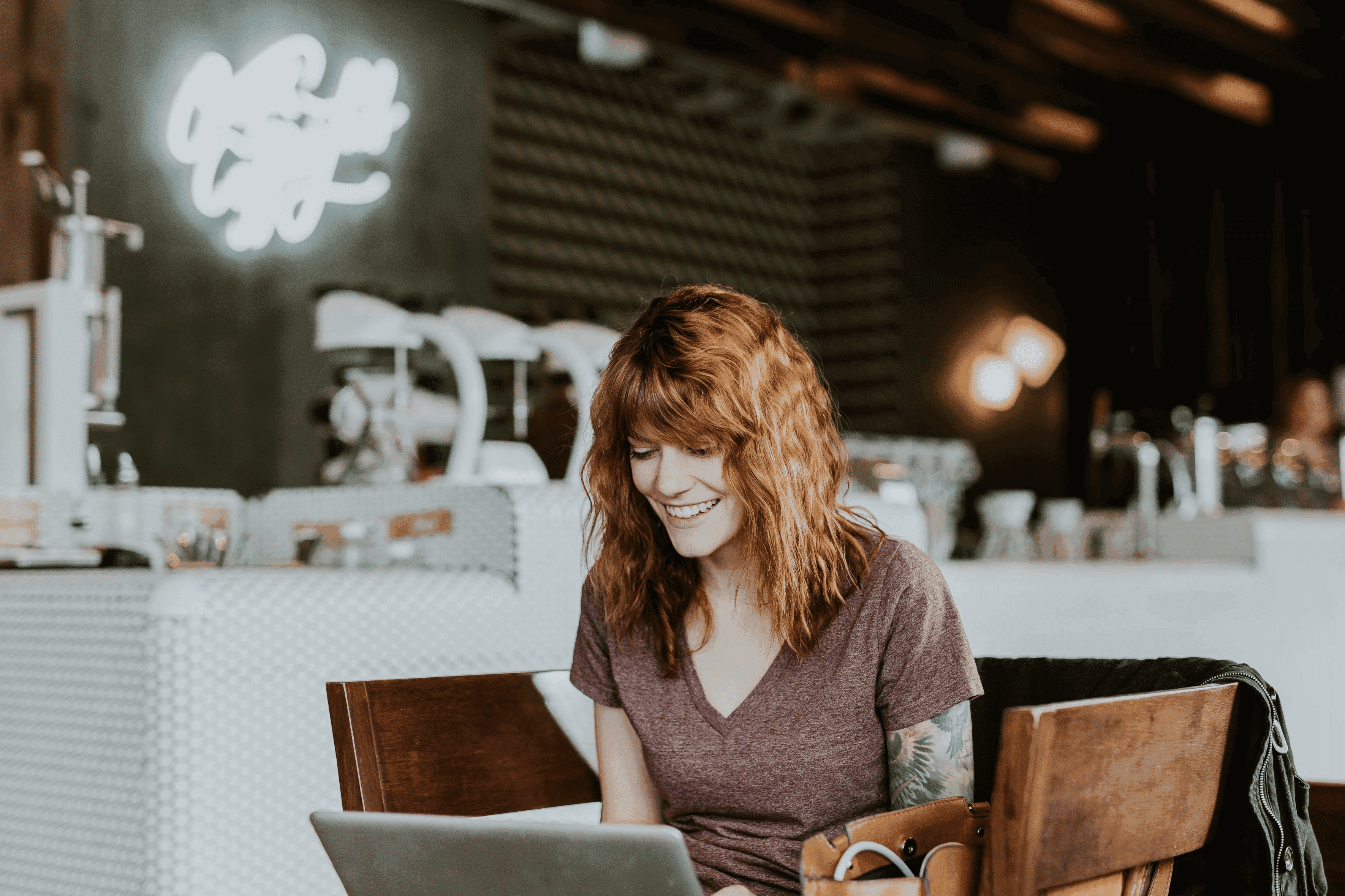 Une photo d'une femme dans un restaurant avec un appareil digital sur ses cuisses