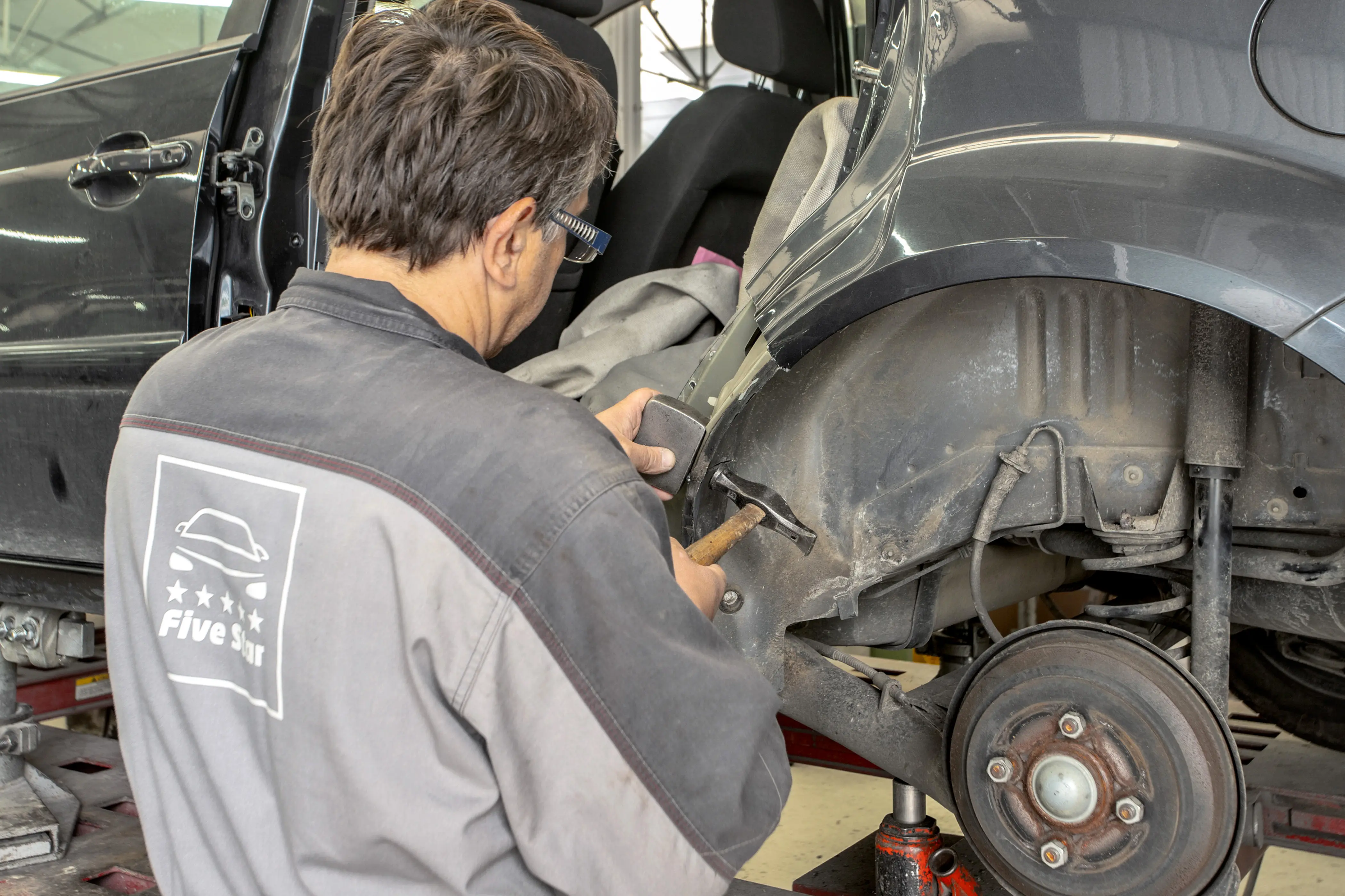 Technicien five star qui répare une carrosserie