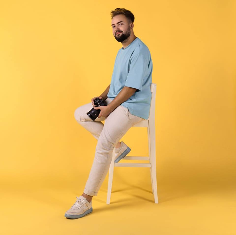 Monochrome product shot: black-capped cosmetic bottle with dynamic water splash on a clean white background.