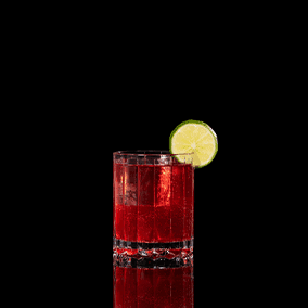 A closeup of a Pomegranate Mule drink against a dark background.