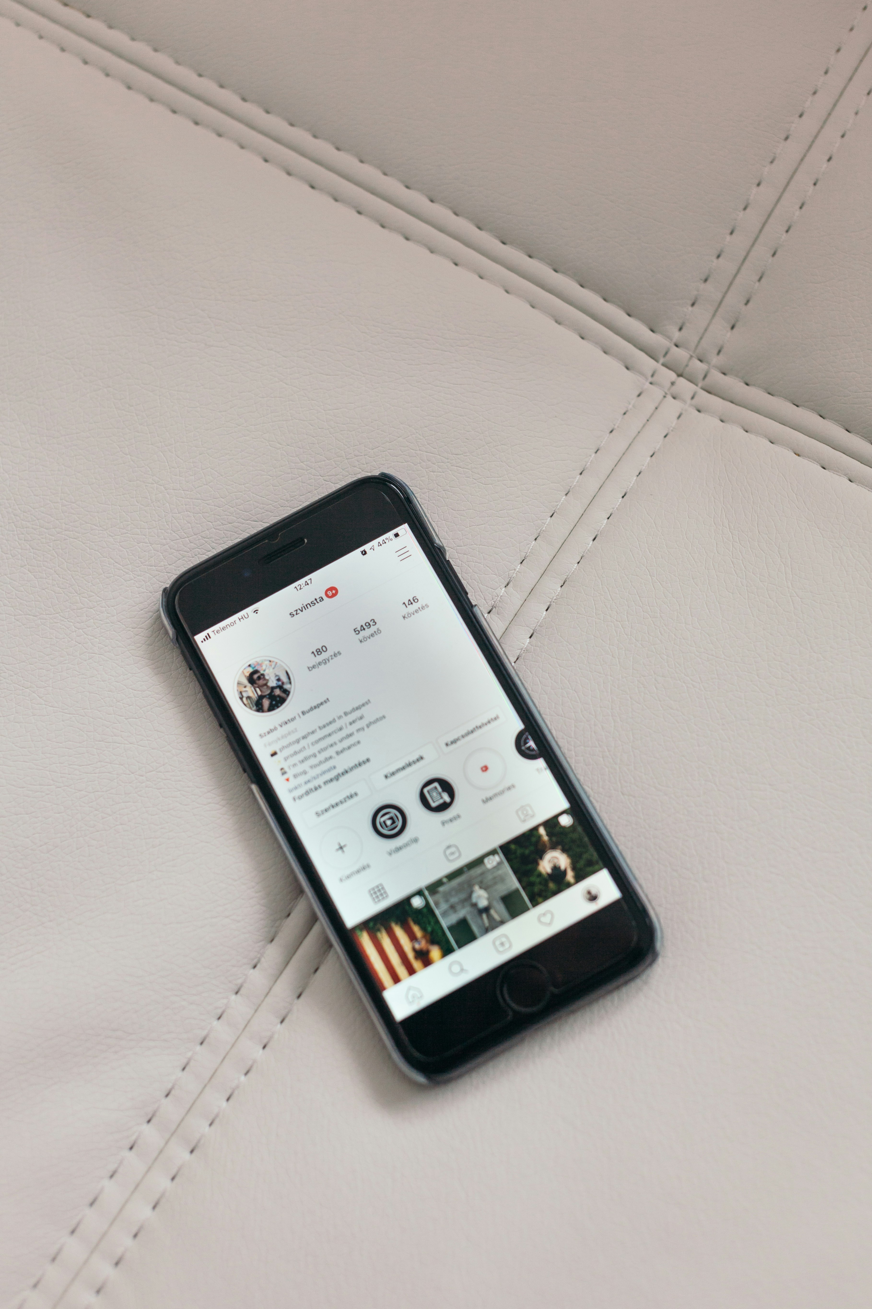 a cell phone sitting on top of a white leather couch