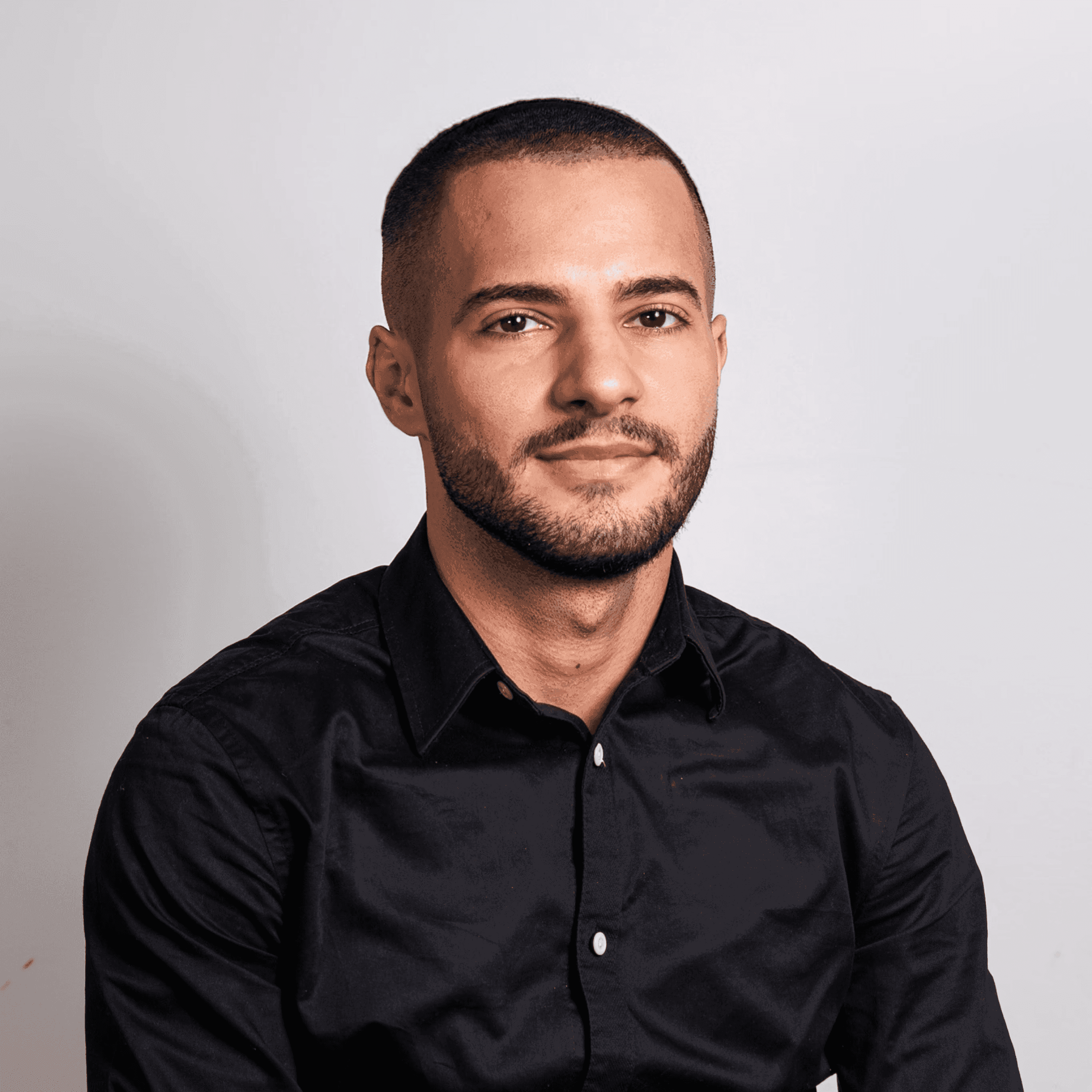 Profile portrait of a man in a white shirt against a light background