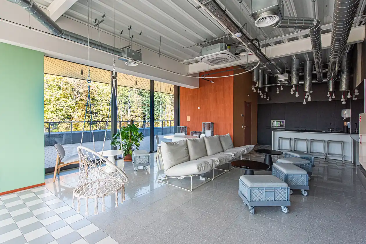 Spacious communal lounge in Vilnius student accommodation with sofas, shared kitchen and outdoor terrace access.