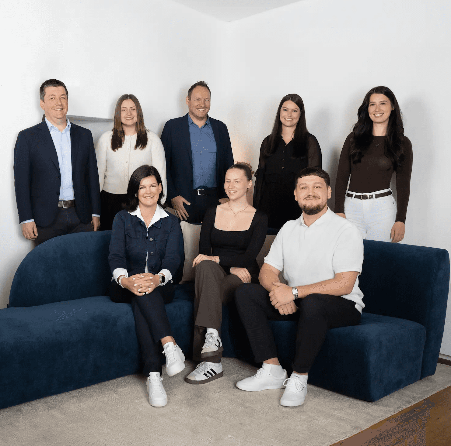 Gesamtes Kocher Immobilien Team sitzt auf einem Sofa in der ImmoLounge
