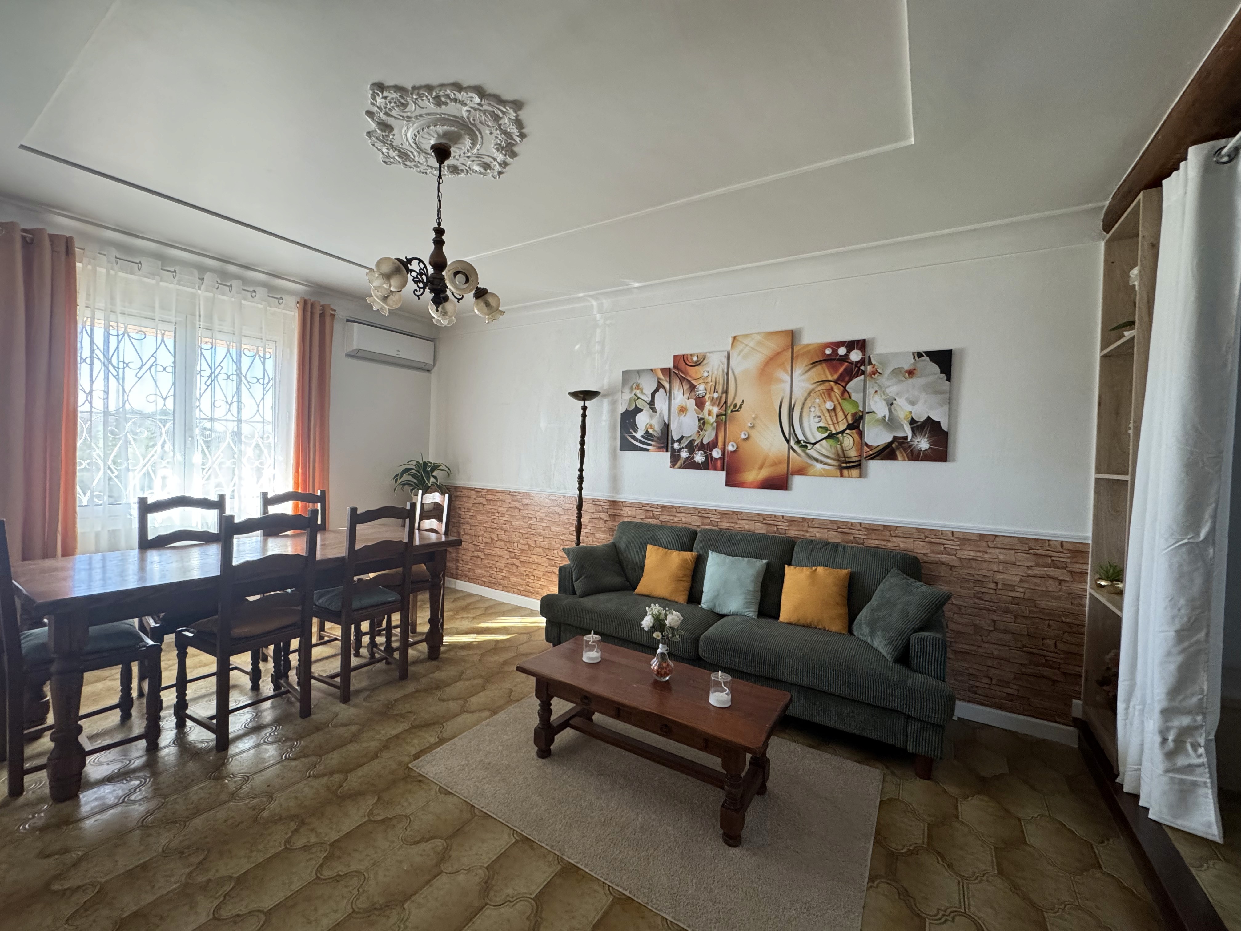 Salon avec salle à manger, canapé, table basse et décoration murale