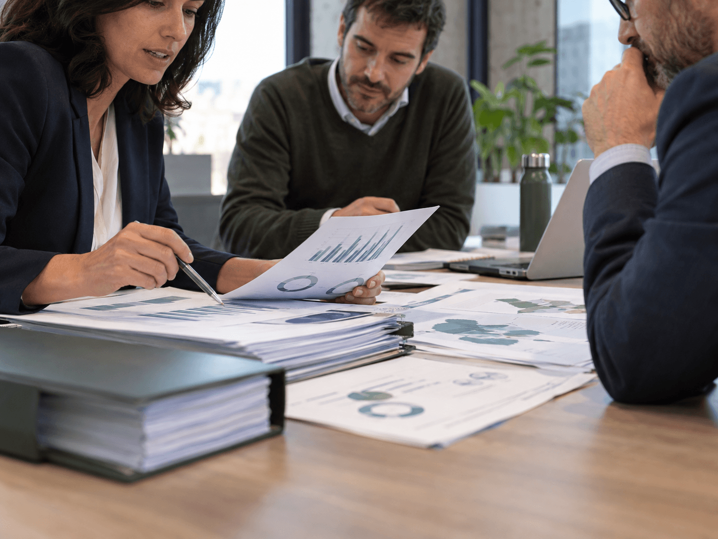 Revisión de informes de sostenibilidad entre equipo financiero y ambiental, documentos como elemento principal.
