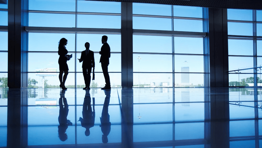 Franchise owners walking through a modern office building, representing standardised operations across multiple locations.