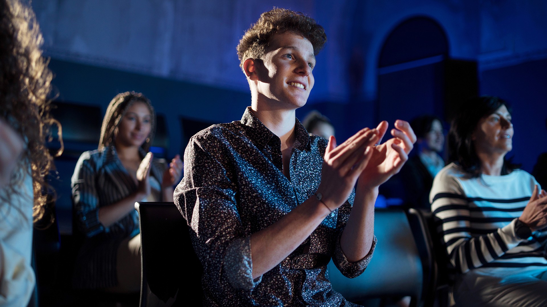 Happy attendee clapping in hall